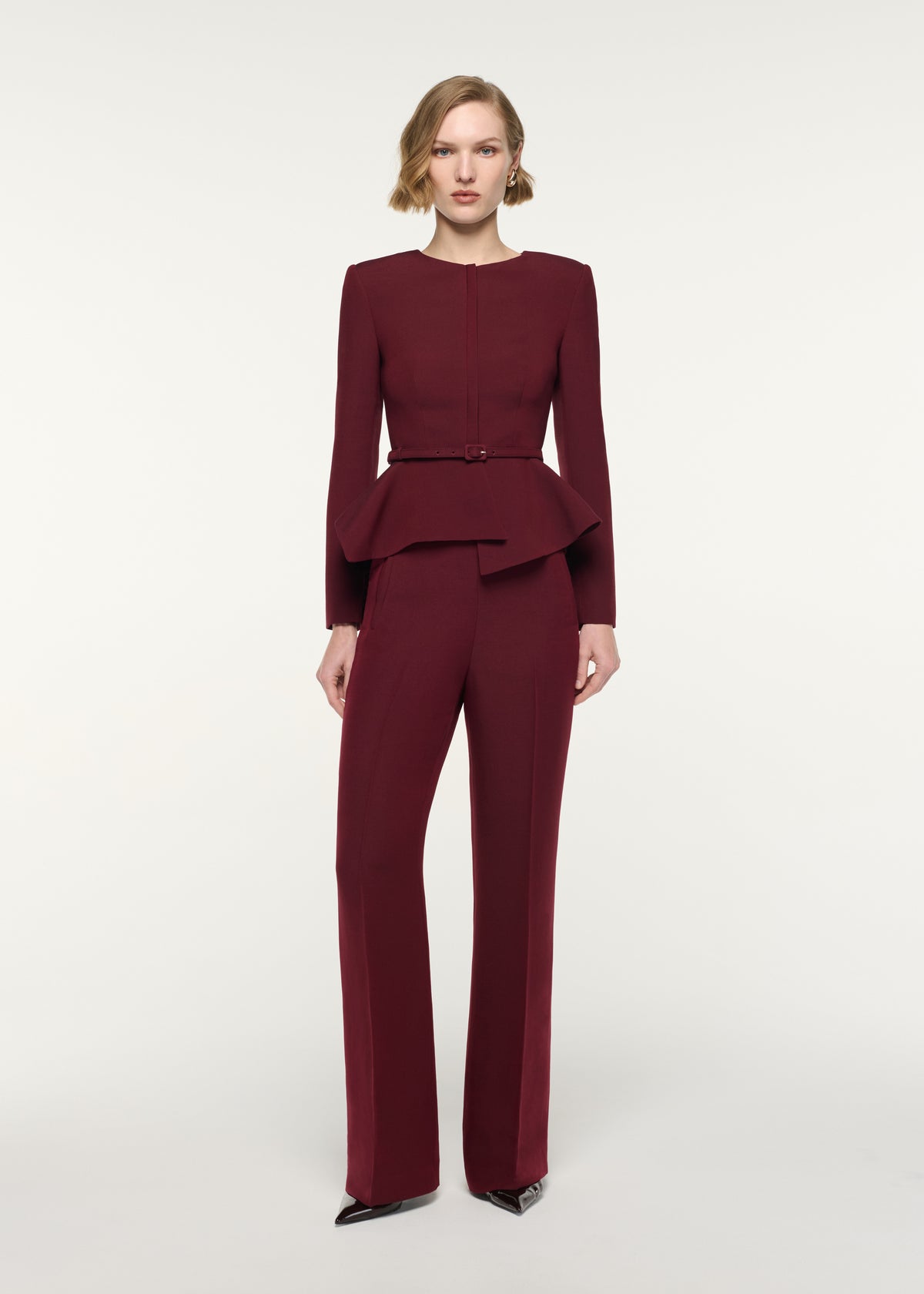 Front view of a model wearing the Origami Drape Peplum Jacket