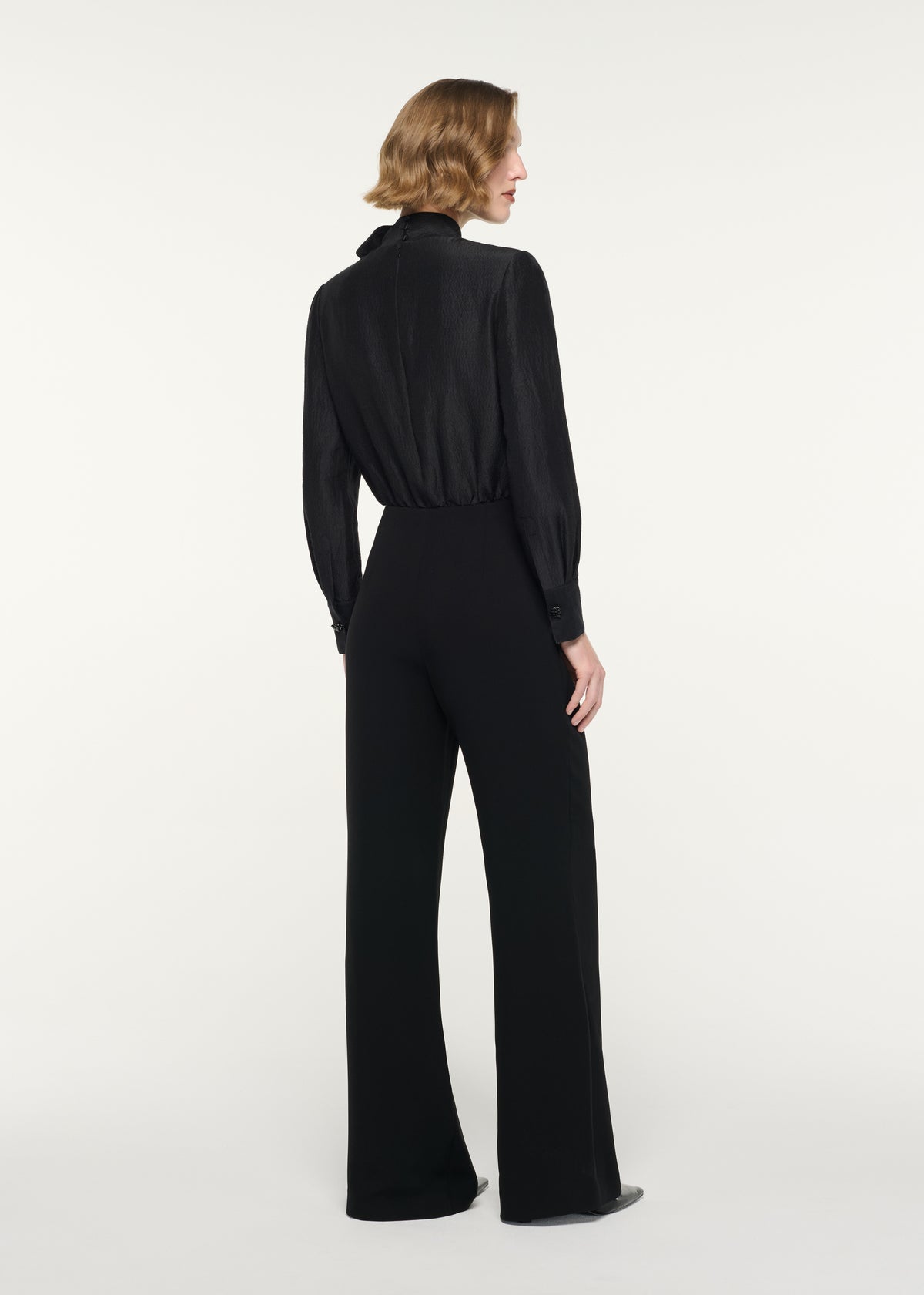 Back view of a model wearing the Draped Slim Fit Trouser