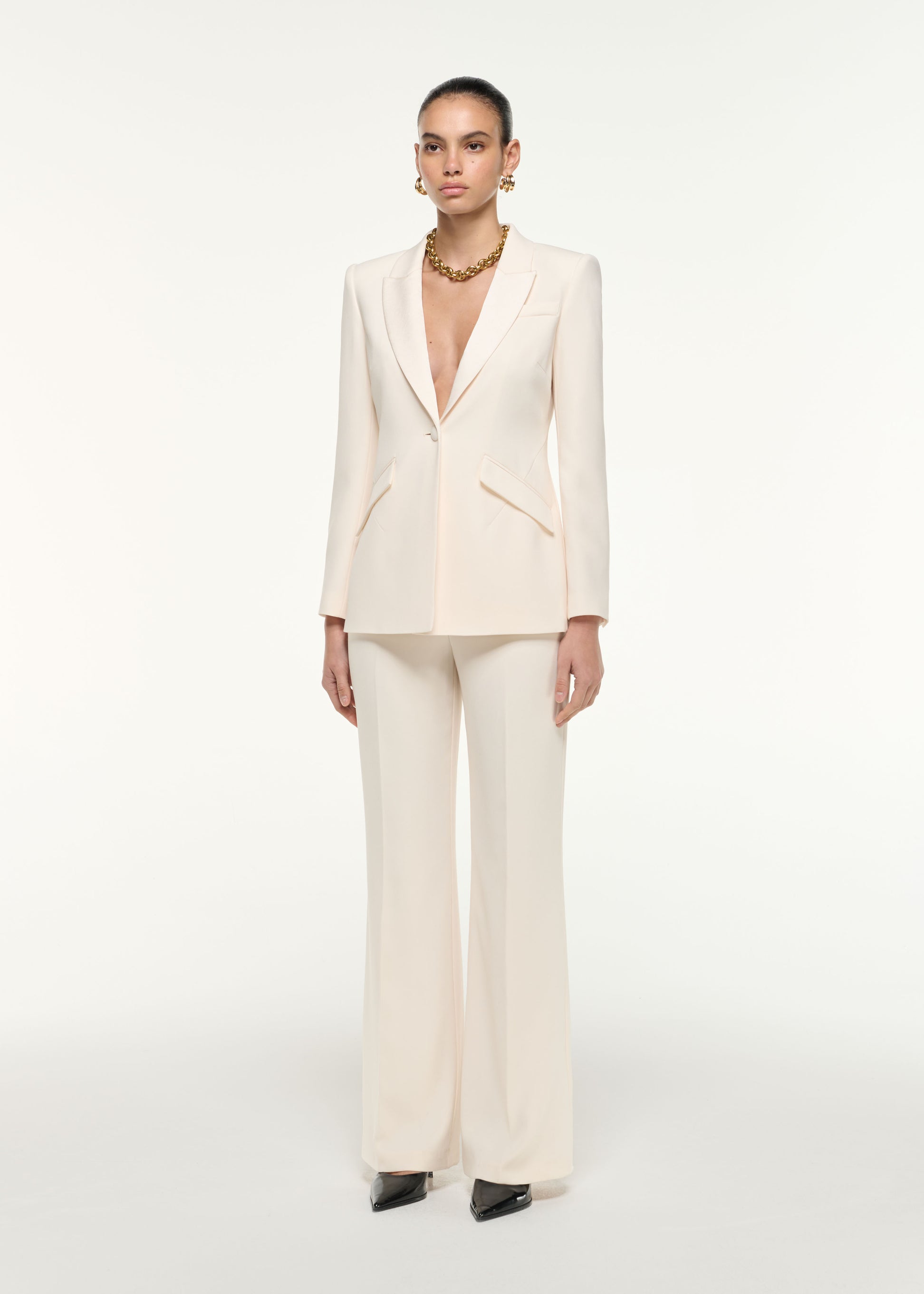 Side view of a model wearing the Satin Crepe Trouser in Cream