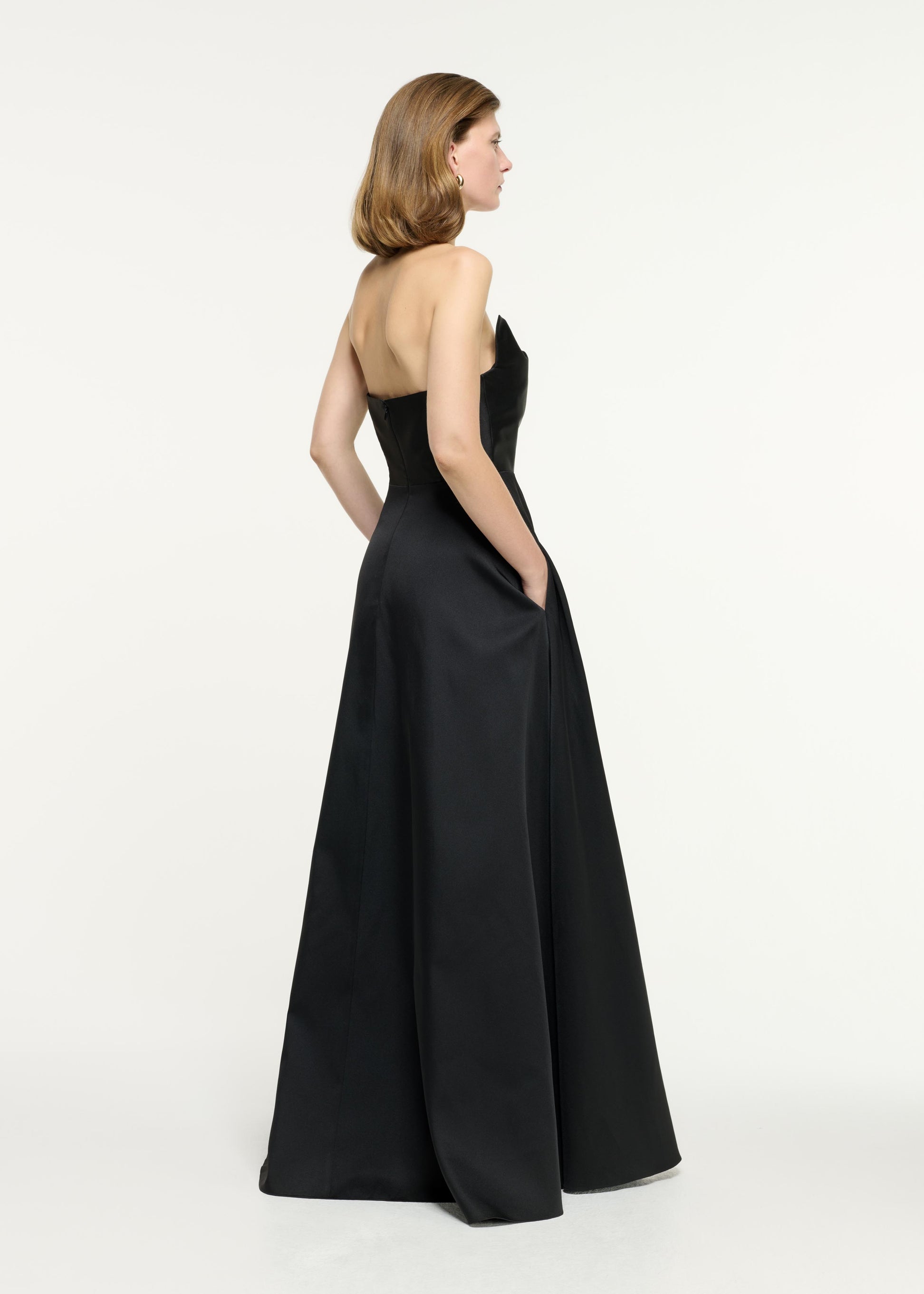 Back view of a model wearing the Strapless Taffeta Gown in Black