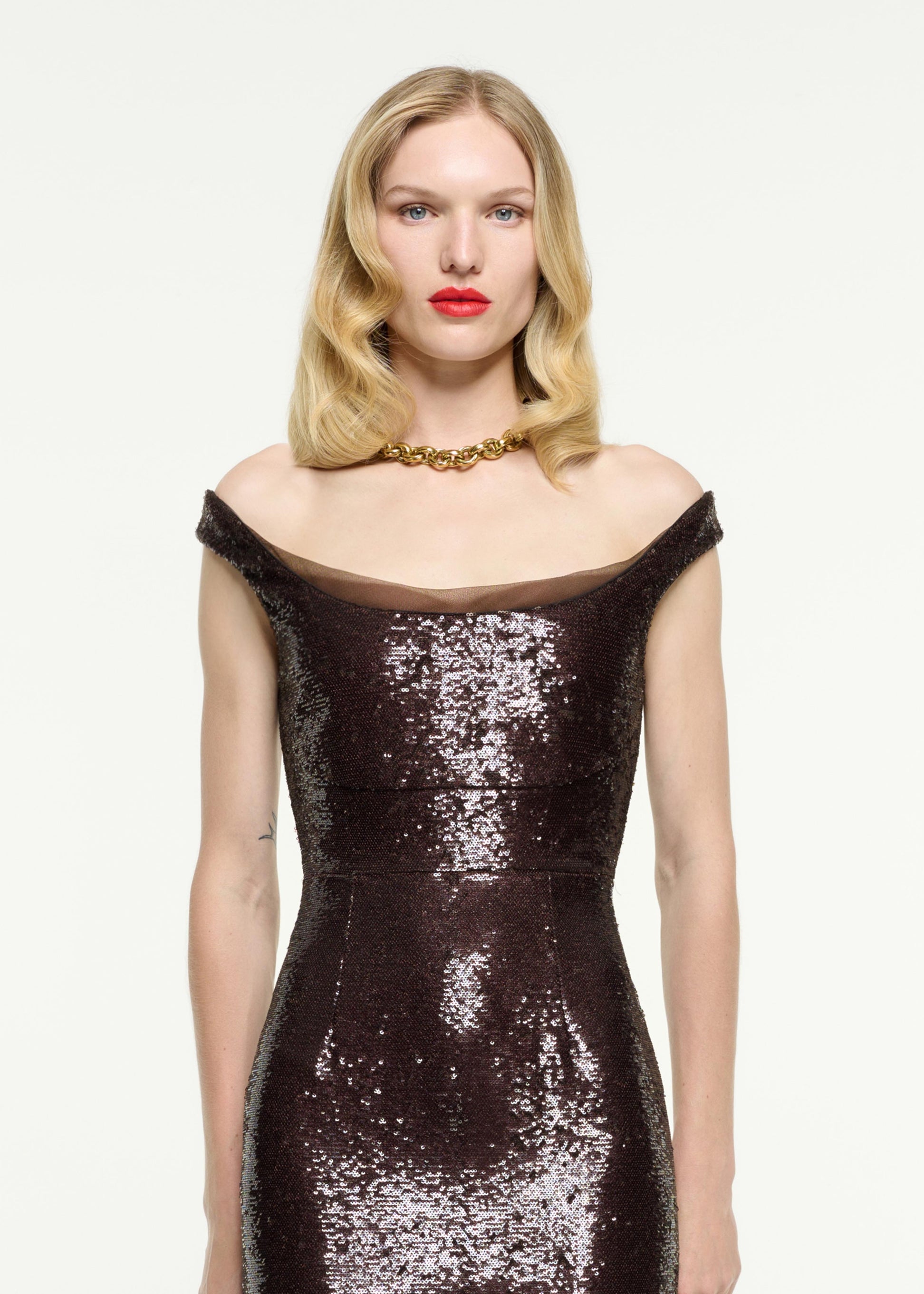 Close up of a model wearing the Off The Shoulder Sequin Gown in Brown