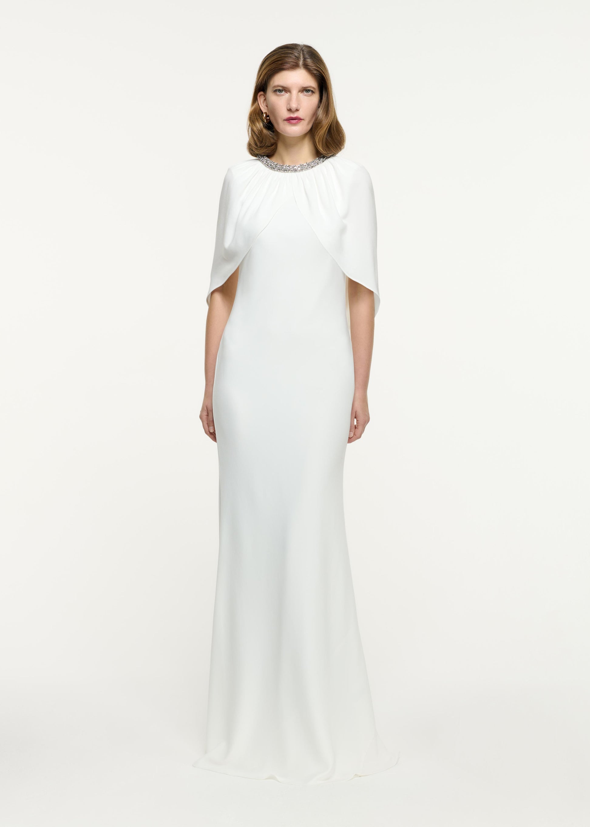 Front view of a model wearing the Embellished Cape Satin Crepe Gown in White