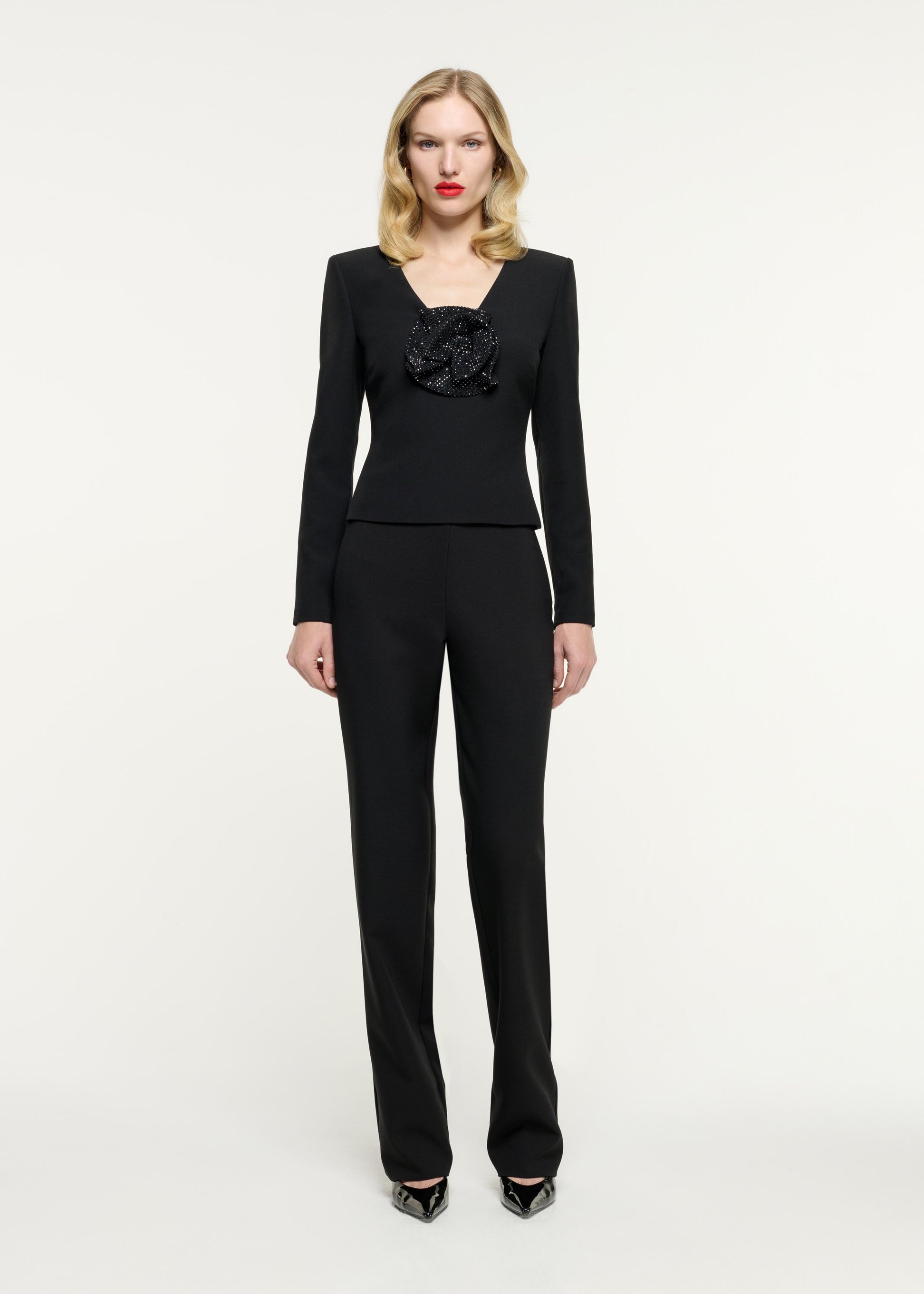 Front view of a model wearing the Embellished Flower Crepe Top in Black