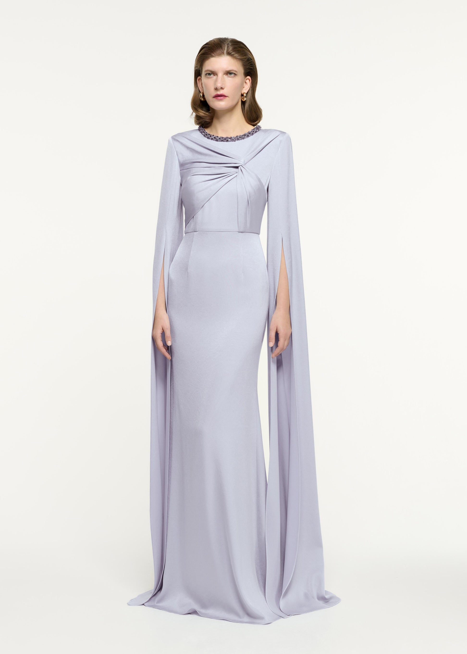 Side view of a model wearing the Cape Sleeve Embellished Gown in Lavender