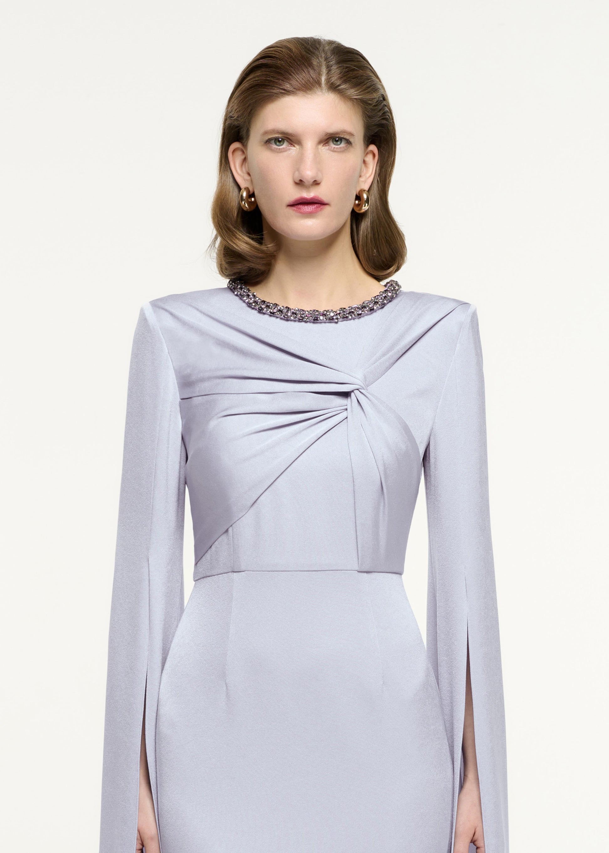 Close up of a model wearing the Cape Sleeve Embellished Gown in Lavender