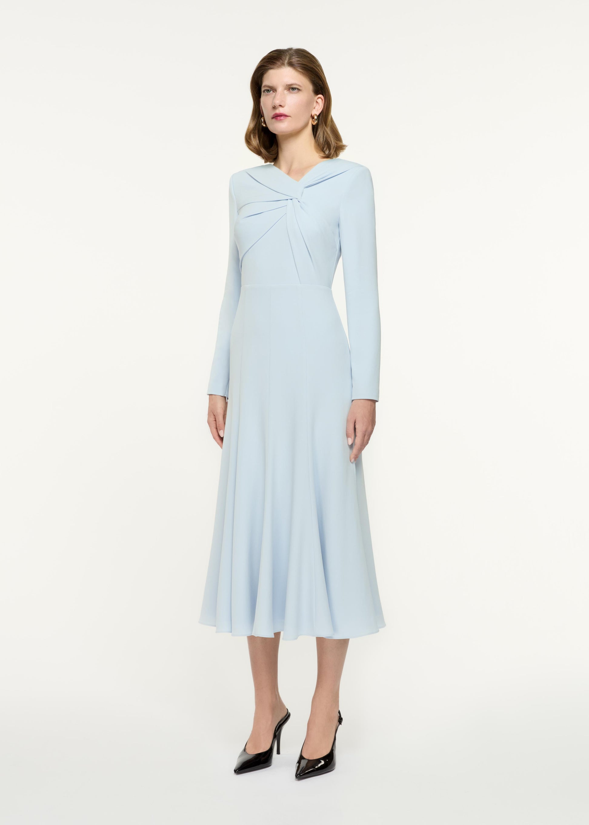 Back view of a model wearing the Long Sleeve Light Cady Midi Dress in Blue