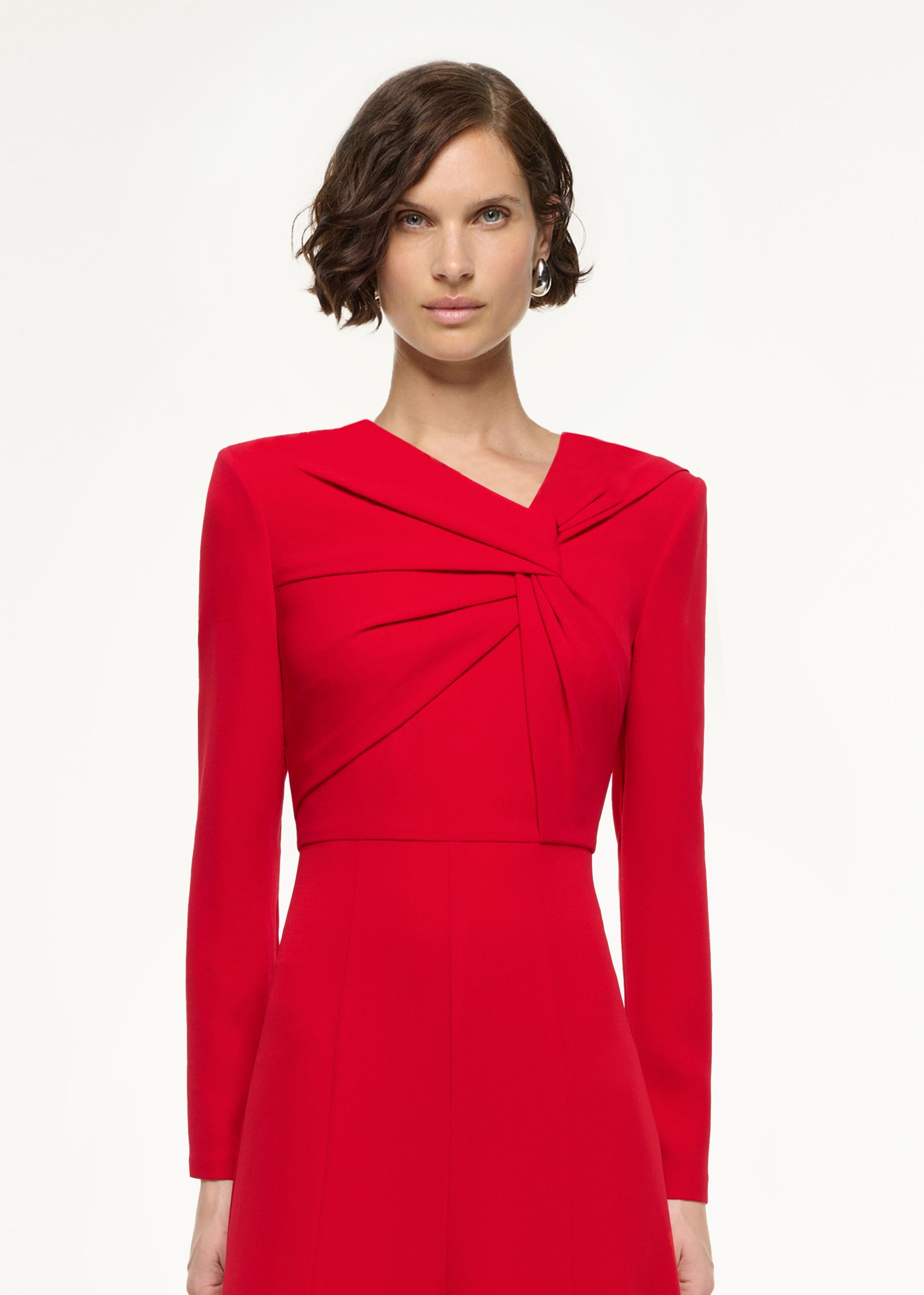 Close up of a model wearing the Long Sleeve Light Cady Midi Dress in Red