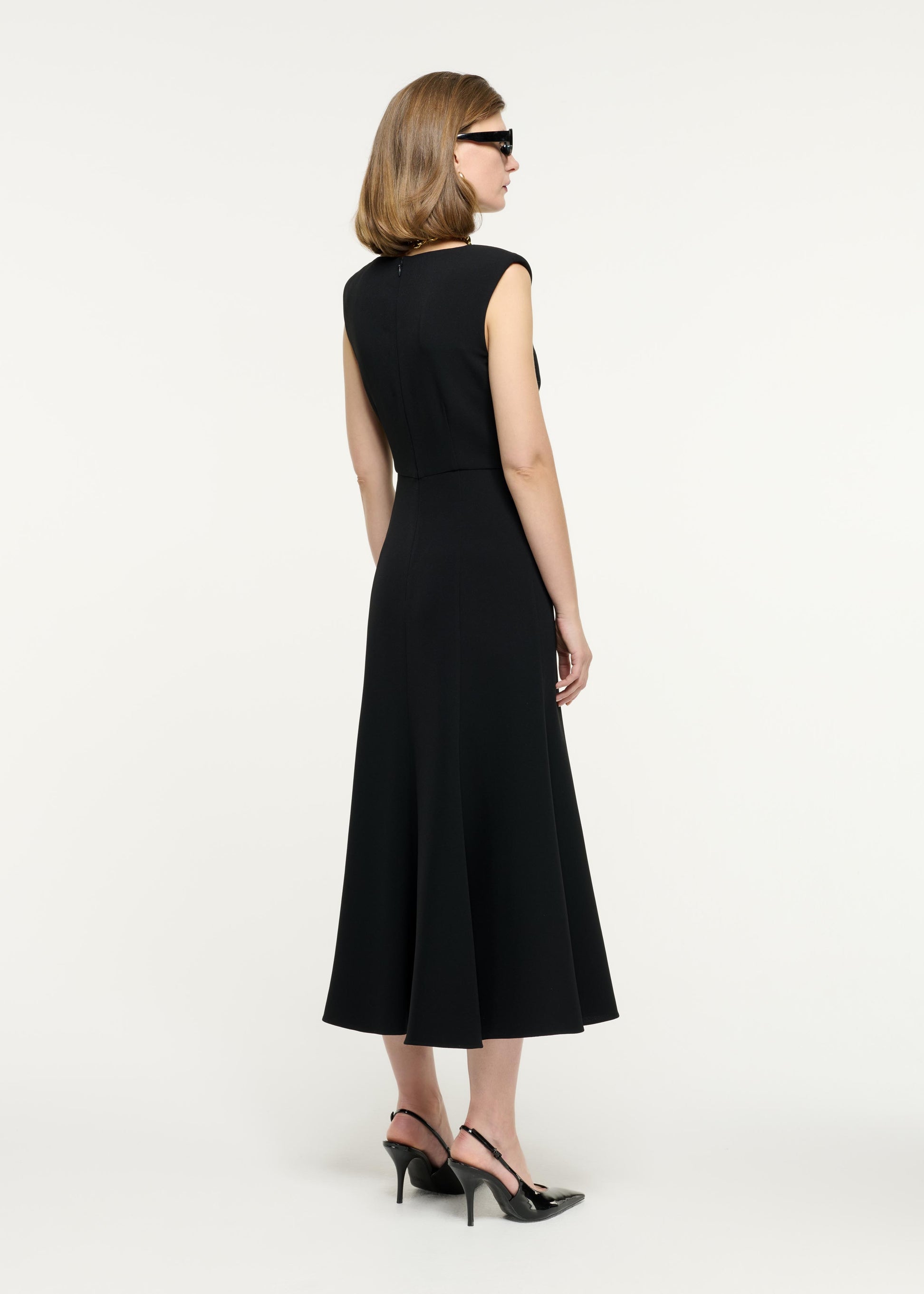 Side view of a model wearing the Sleeveless Light Cady Midi Dress in Black