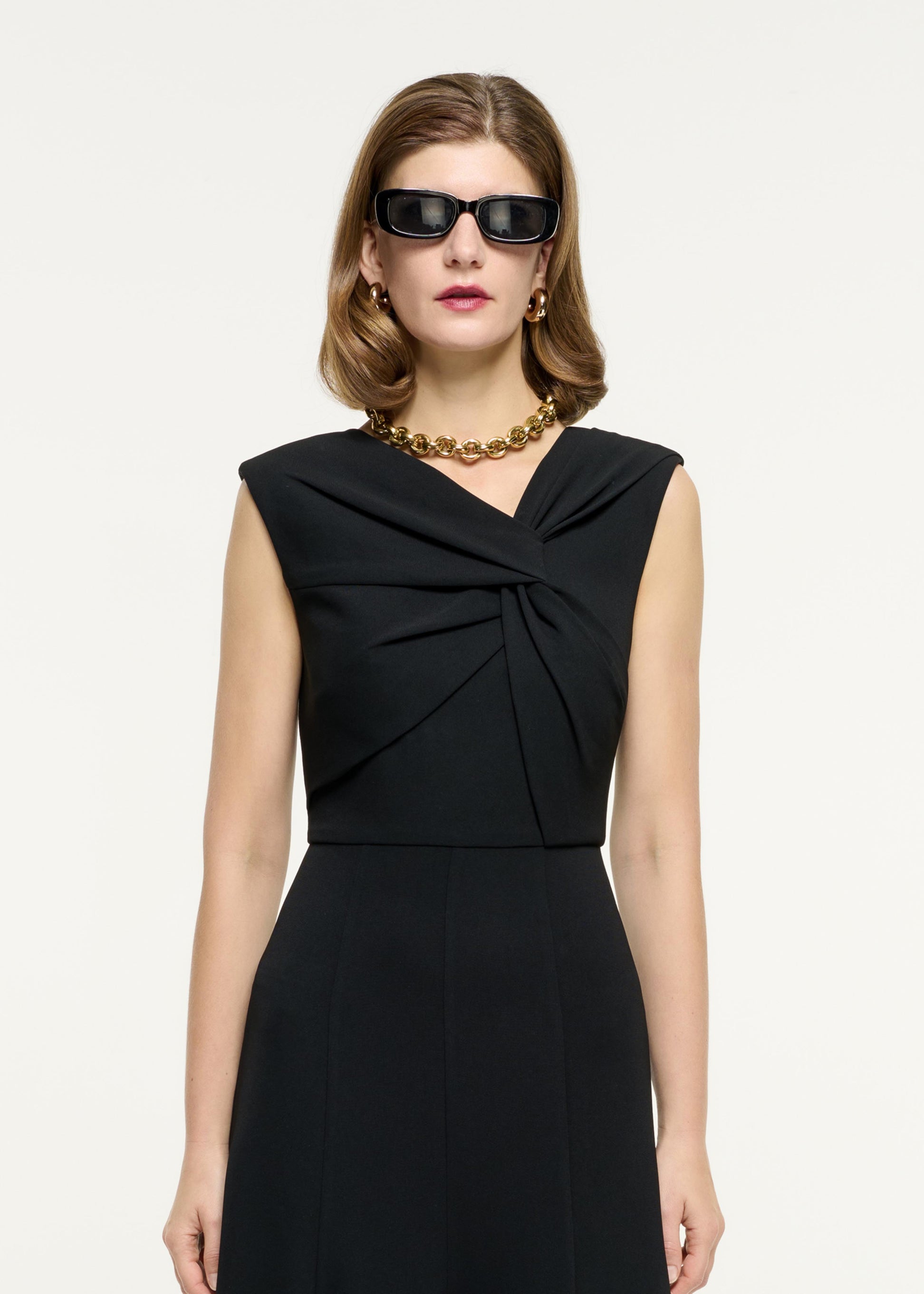 Close up of a model wearing the Sleeveless Light Cady Midi Dress in Black