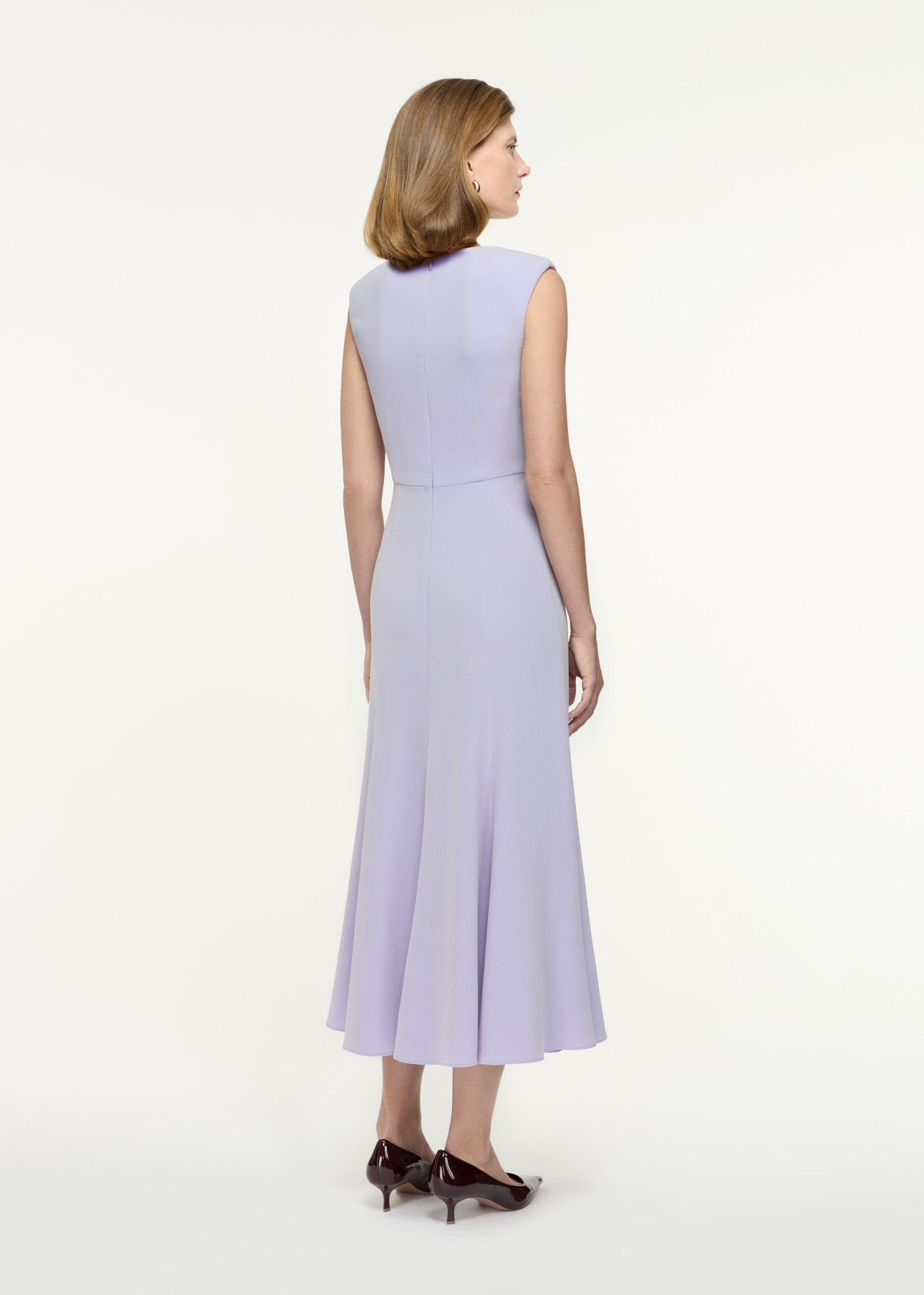 Back view of a model wearing the Sleeveless Light Cady Midi Dress in Purple