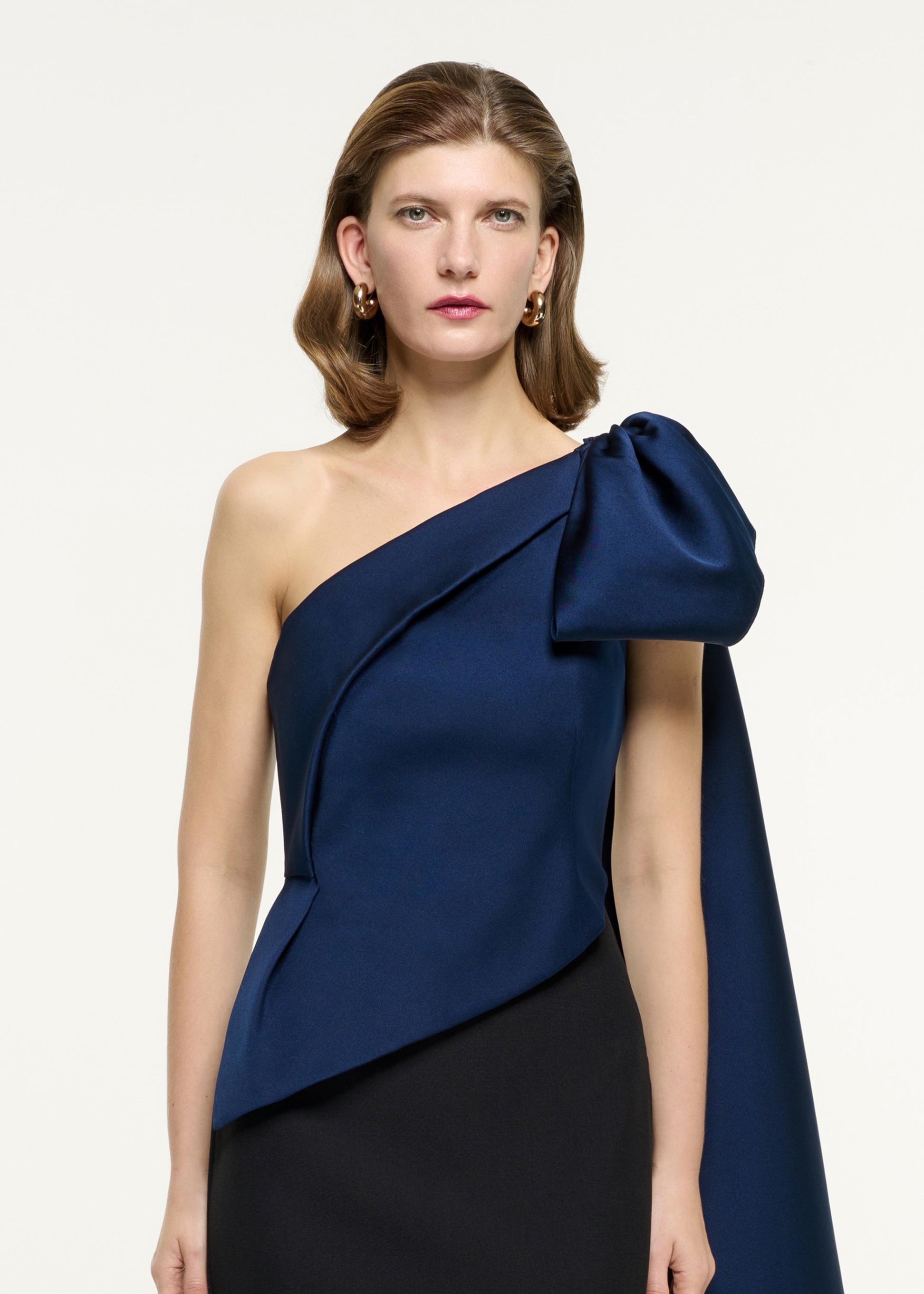 Close up of a model wearing the Asymmetric Taffeta Bow Drape Gown in Blue