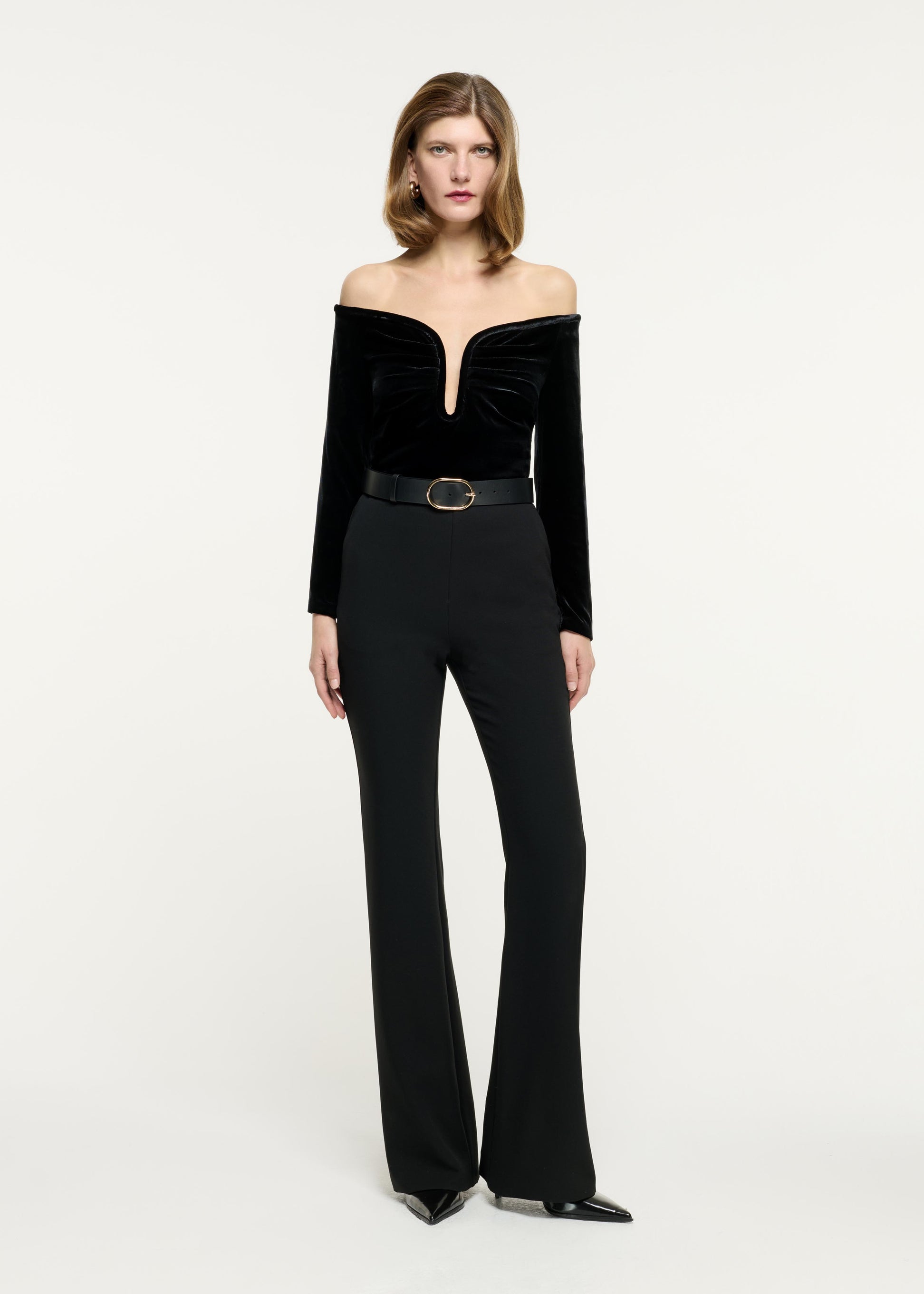 Front view of a model wearing the Off The Shoulder Velvet Top in Black