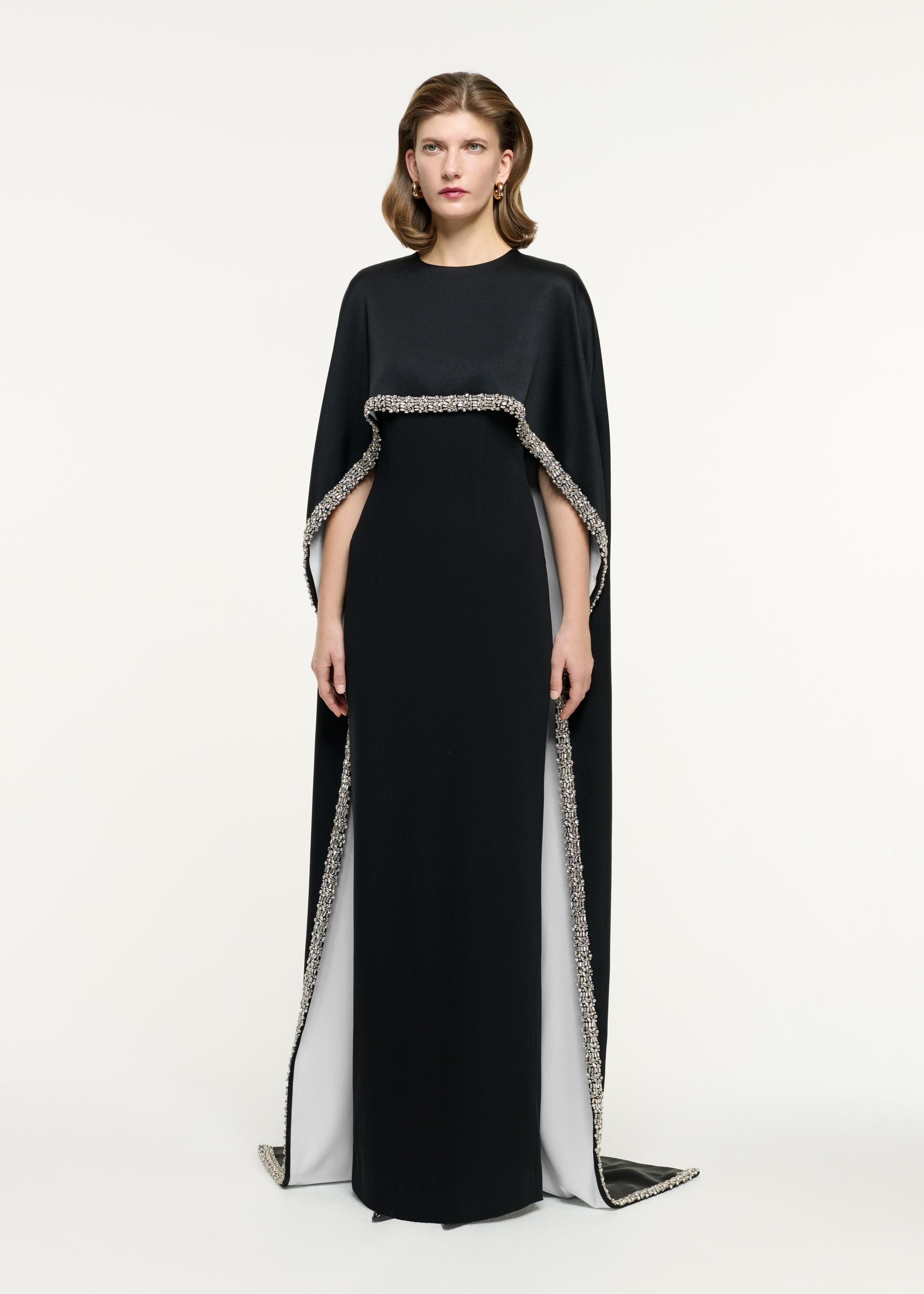 Side view of a model wearing the Embellished Cape Satin Crepe Gown in Monochrome
