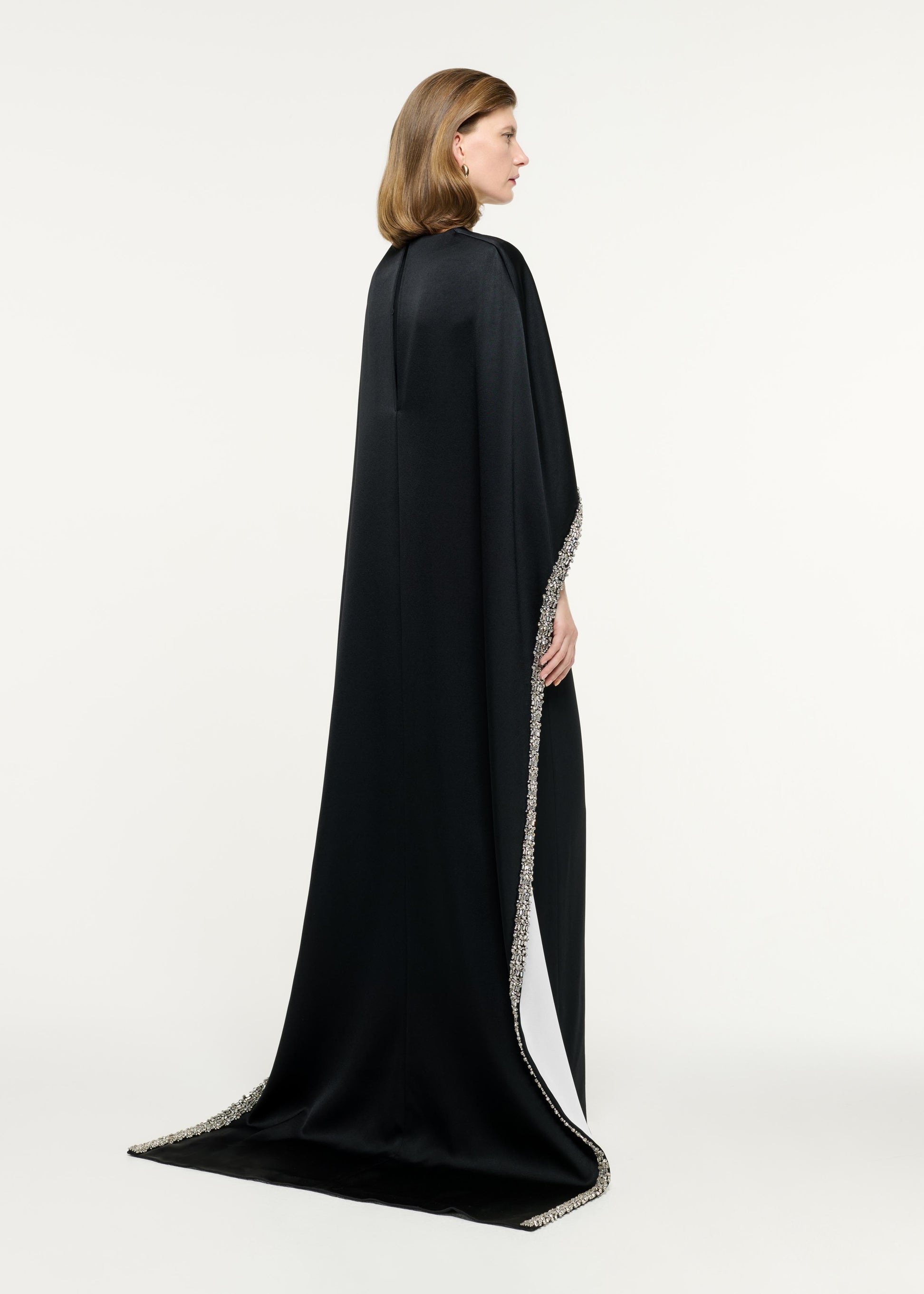Back view of a model wearing the Embellished Cape Satin Crepe Gown in Monochrome