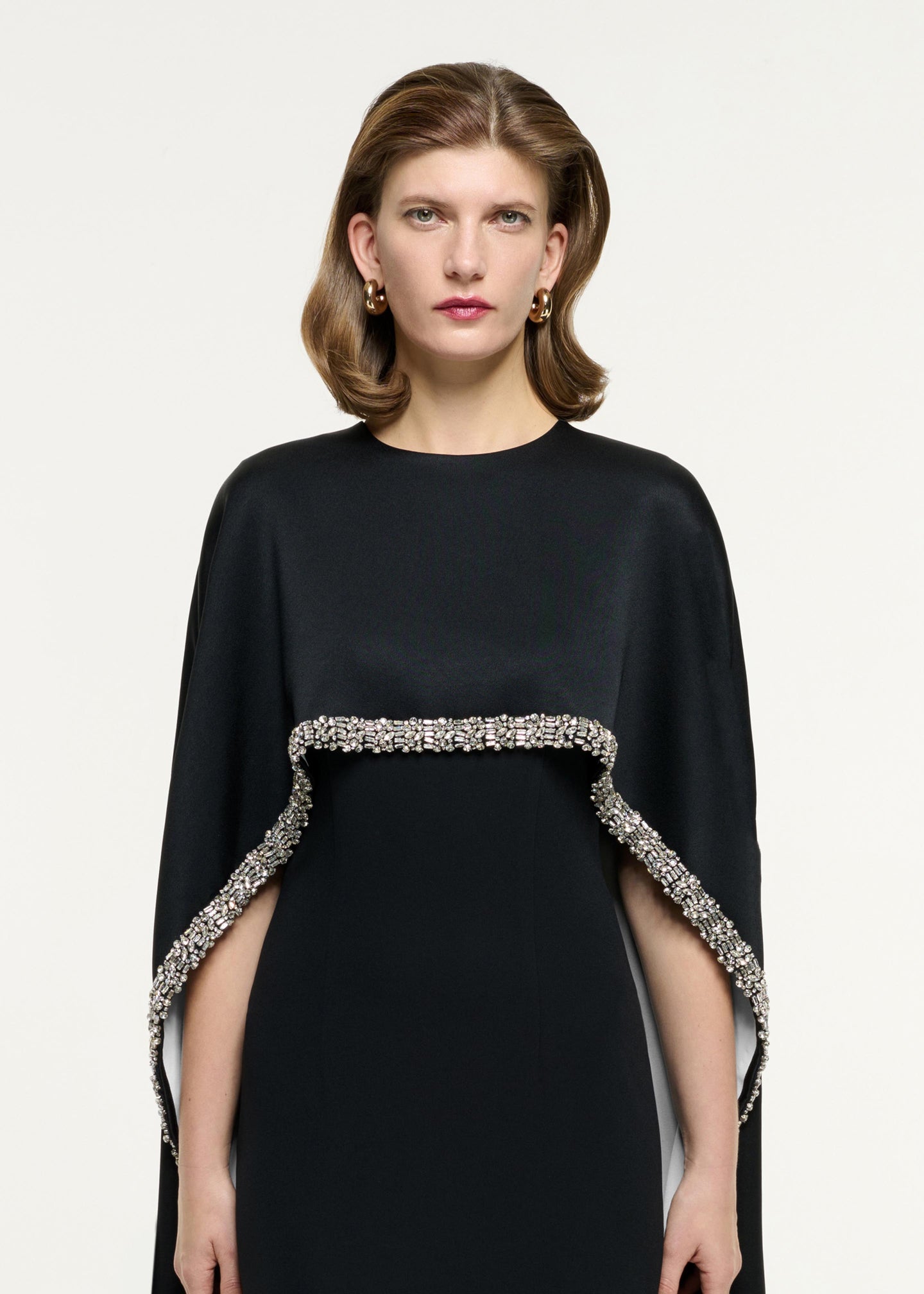 Close up of a model wearing the Embellished Cape Satin Crepe Gown in Monochrome