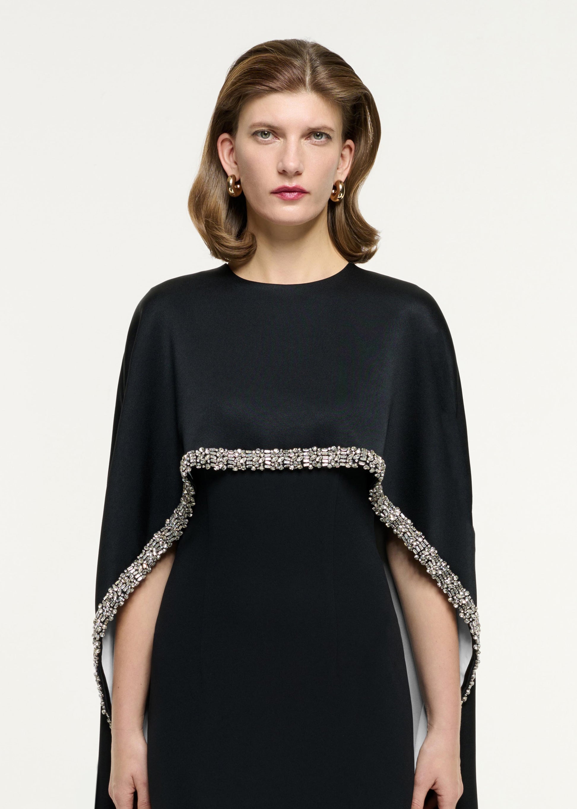 Close up of a model wearing the Embellished Cape Satin Crepe Gown in Monochrome