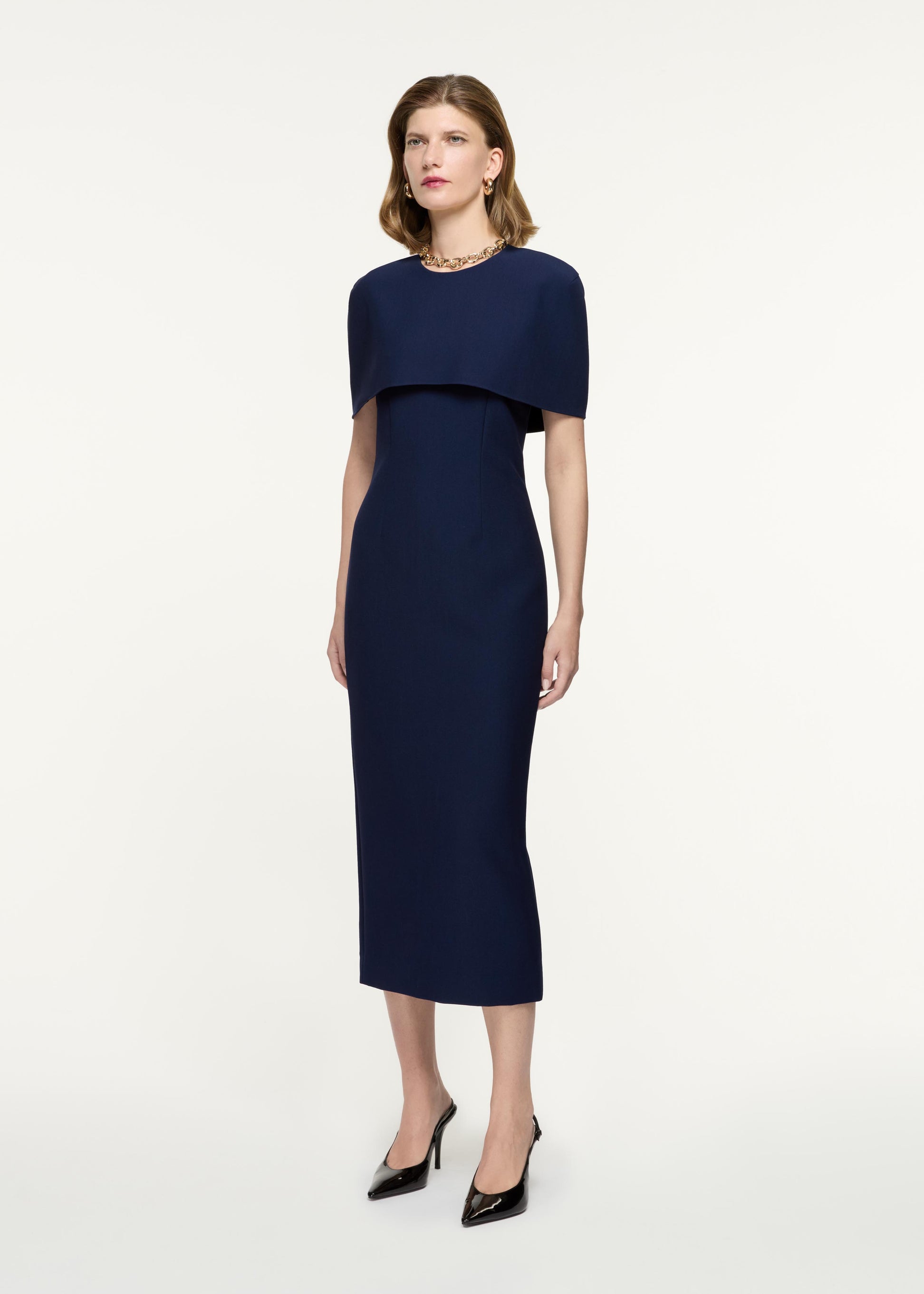 Side view of a model wearing the Cape Crepe Midi Dress in Navy