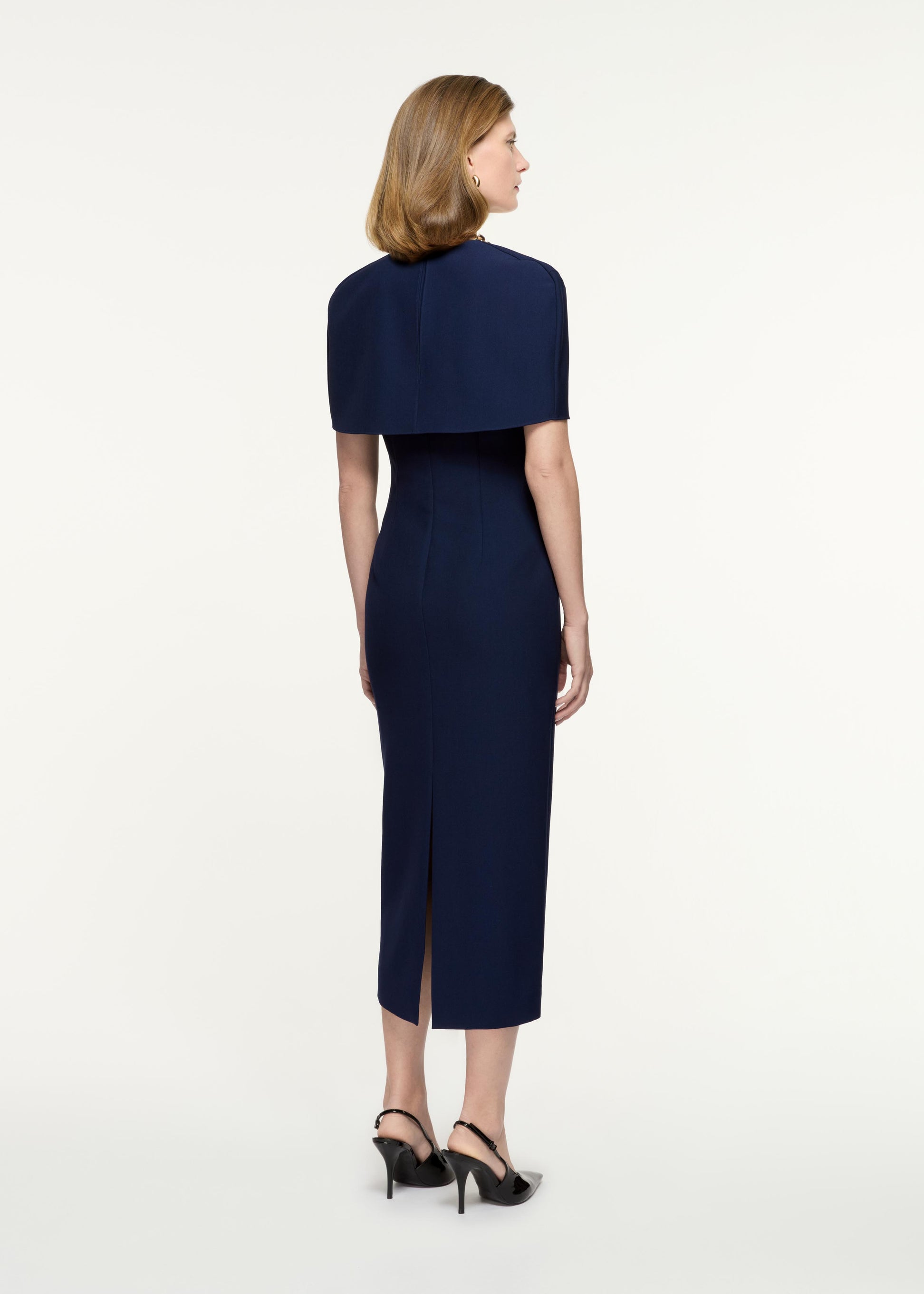 Back view of a model wearing the Cape Crepe Midi Dress in Navy