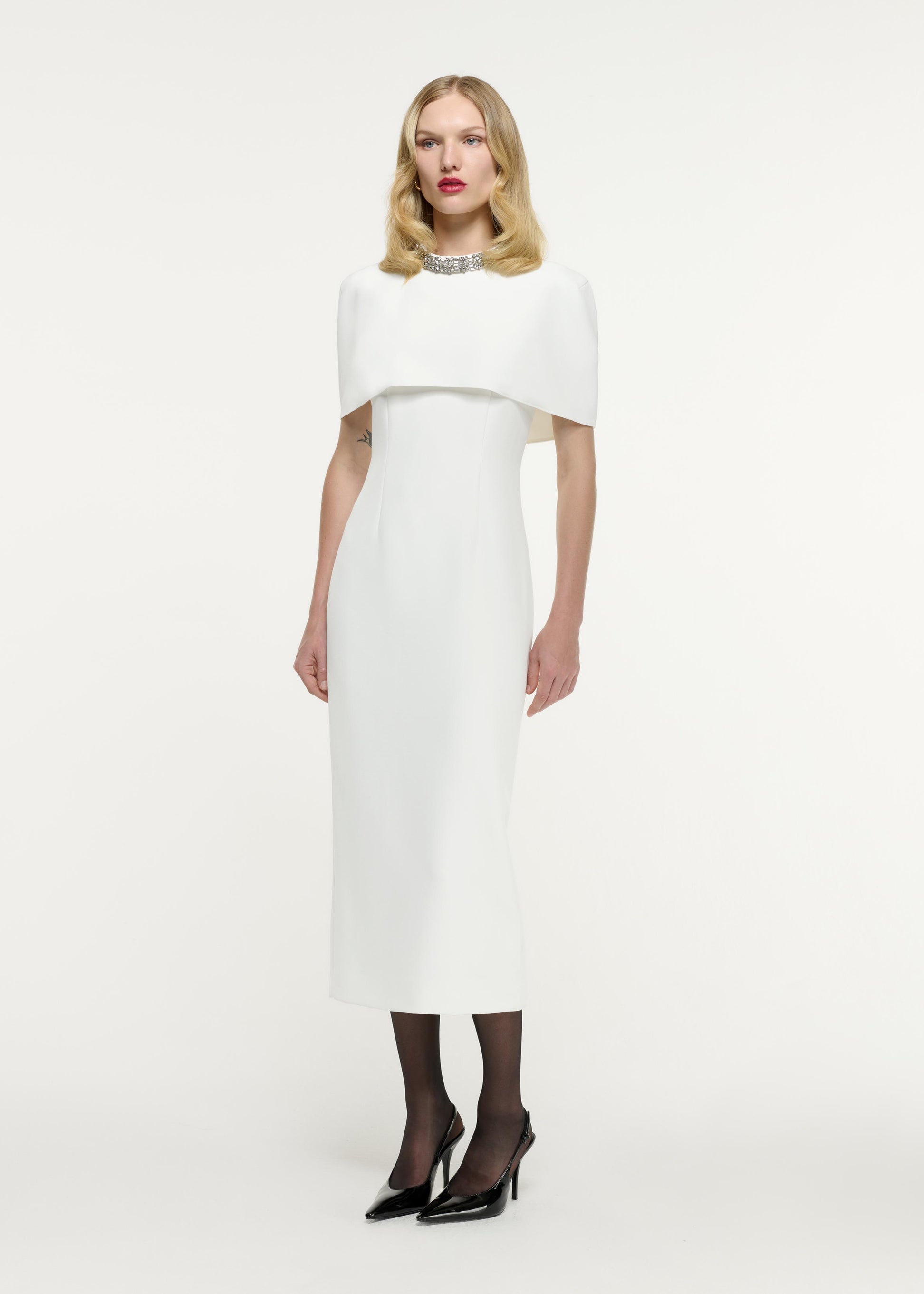 Side view of a model wearing the Cape Embellished Crepe Midi Dress in White