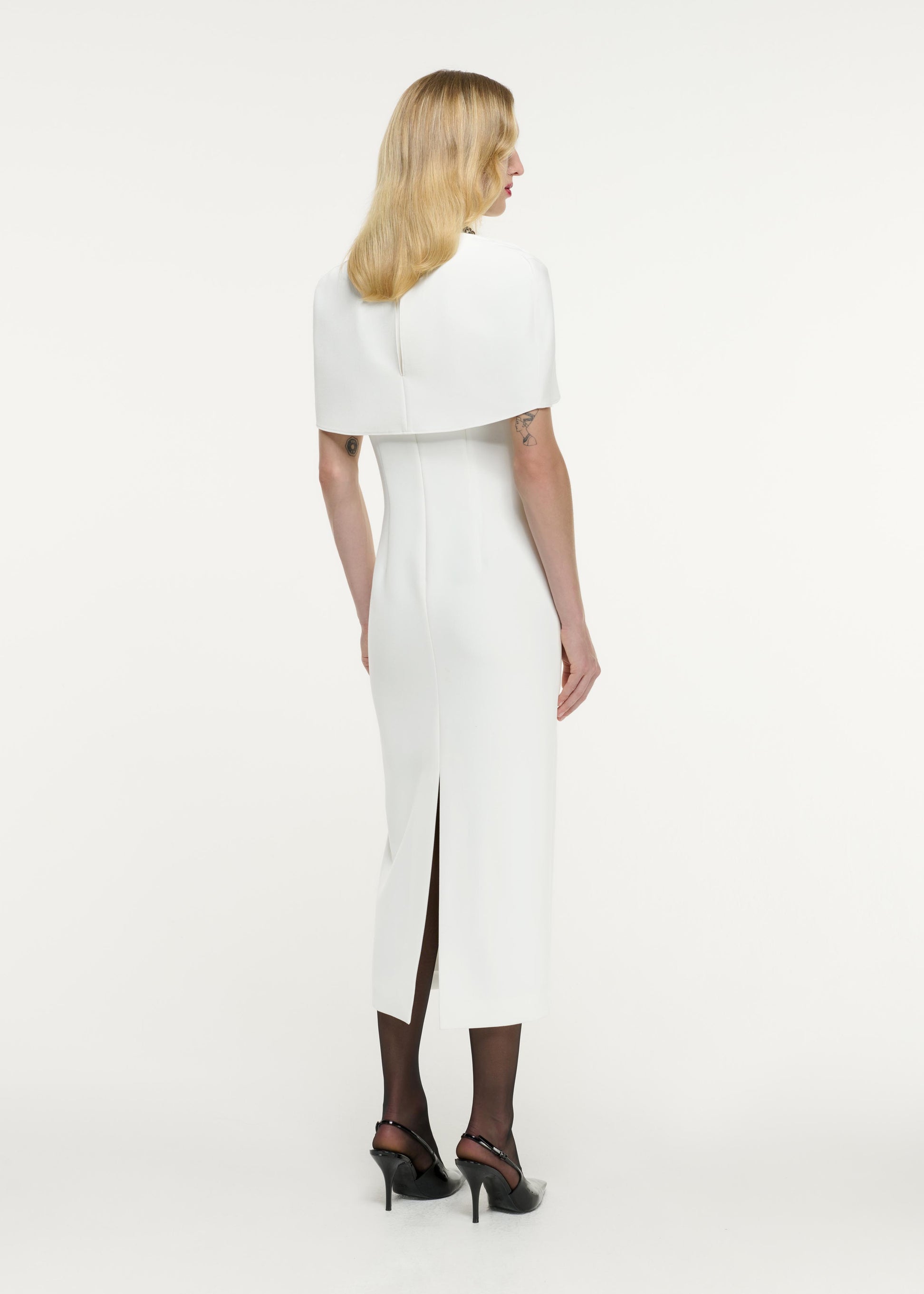 Back view of a model wearing the Cape Embellished Crepe Midi Dress in White