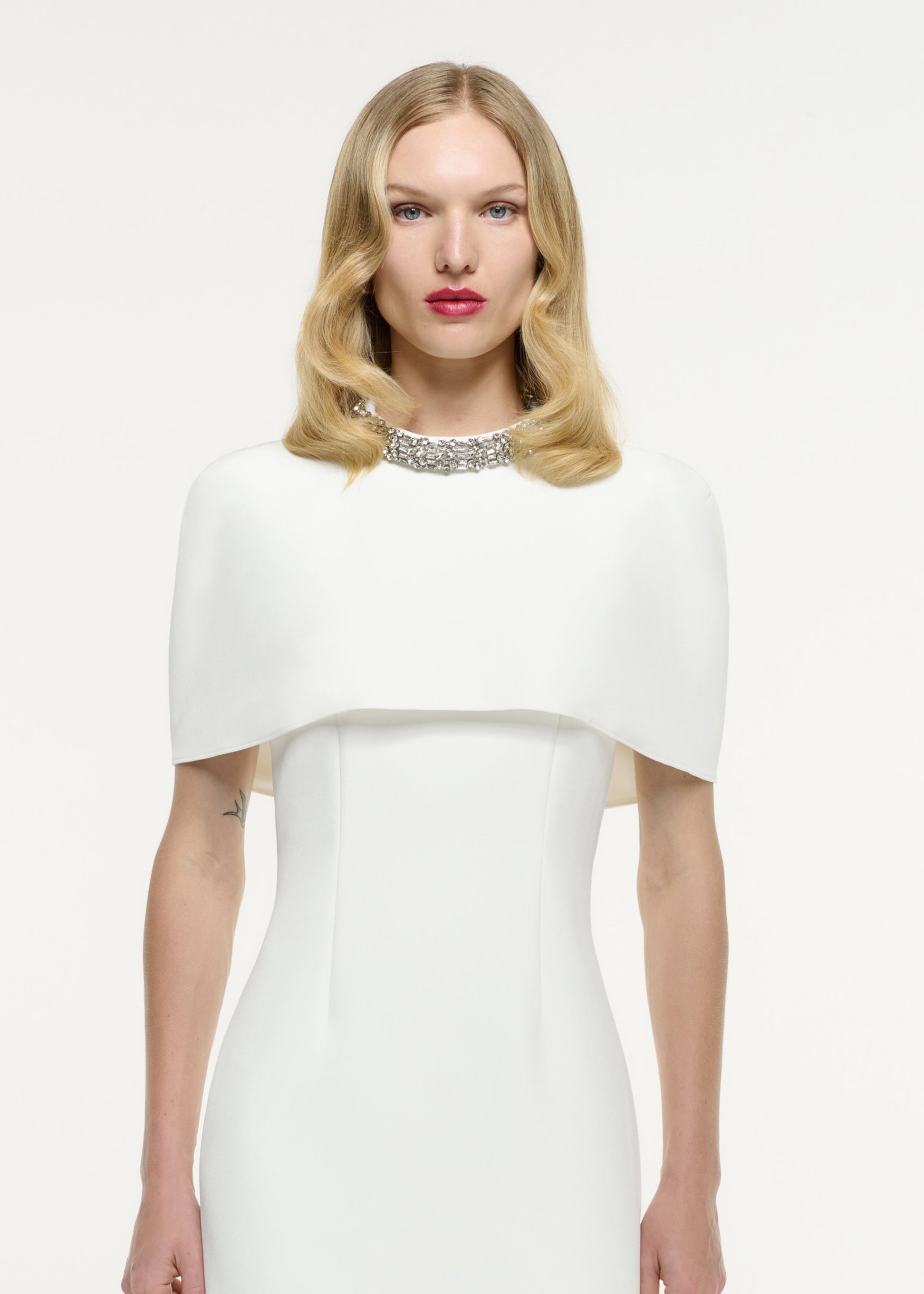 Close up of a model wearing the Cape Embellished Crepe Midi Dress in White