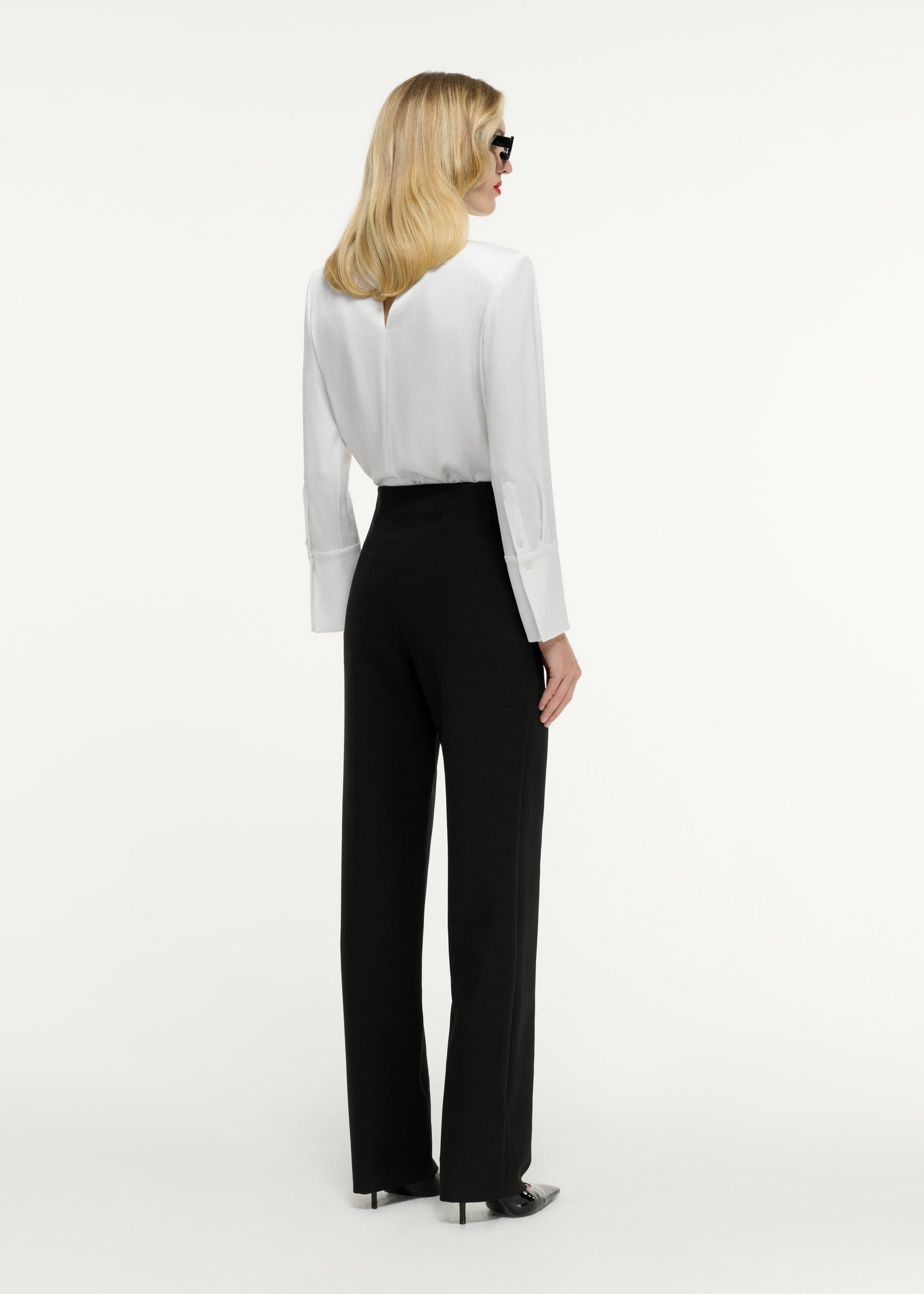 Back view of a model wearing the Long Sleeve Buckle Satin Crepe Top in White