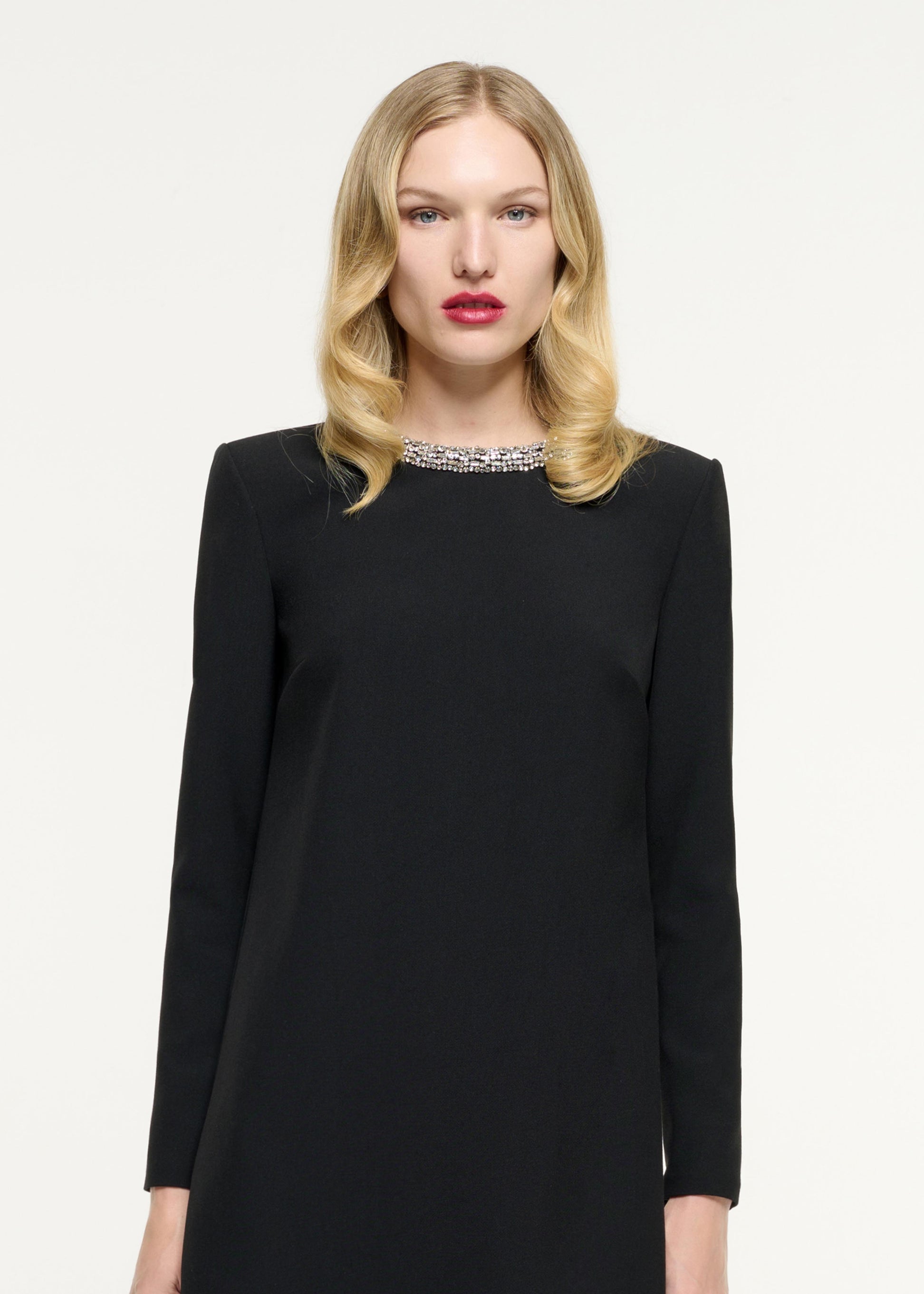Close up of a model wearing the Long Sleeve Embellished Crepe Mini Dress in Black