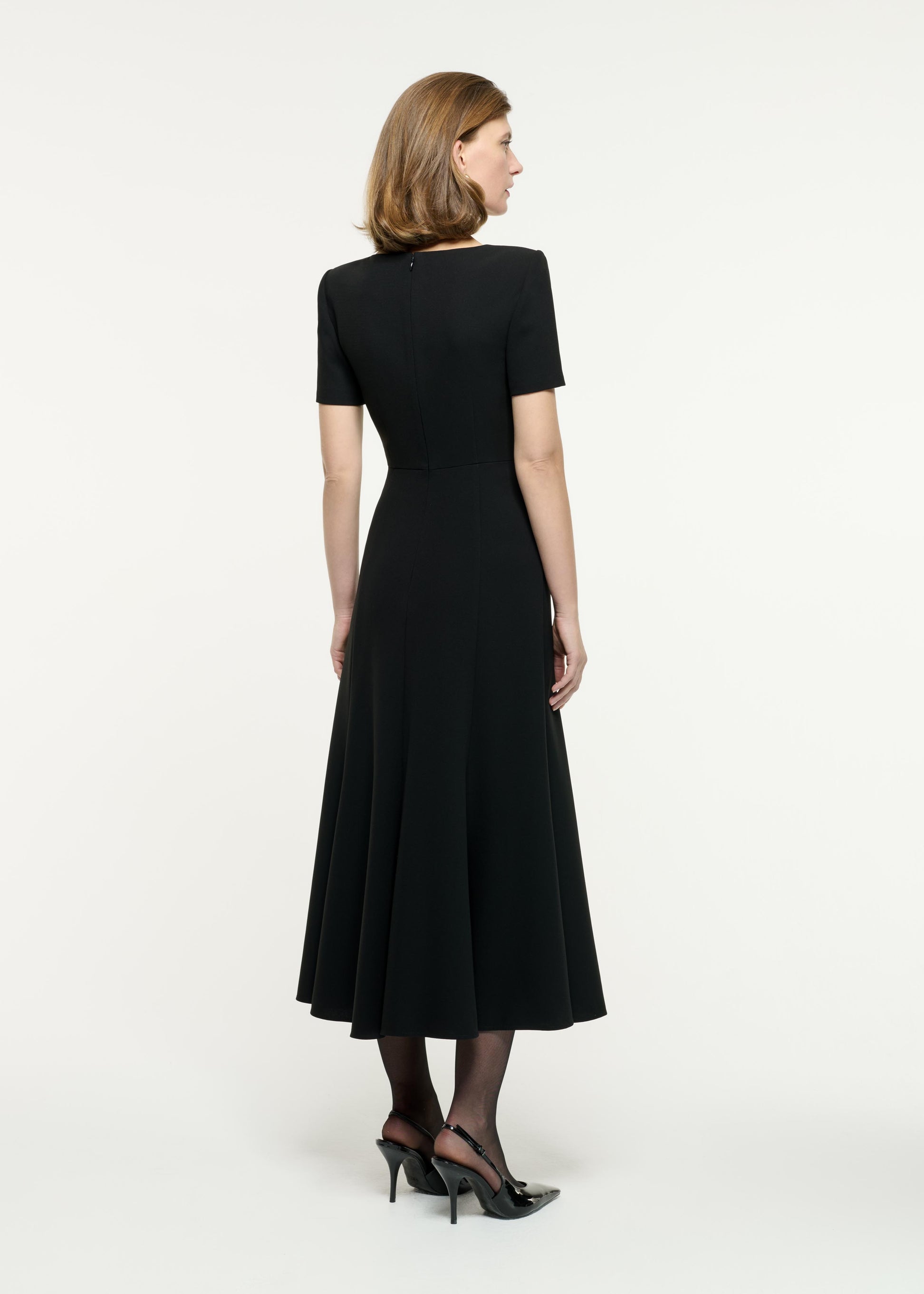 Back view of a model wearing the Contrast Fluted Midi Dress in Monochrome