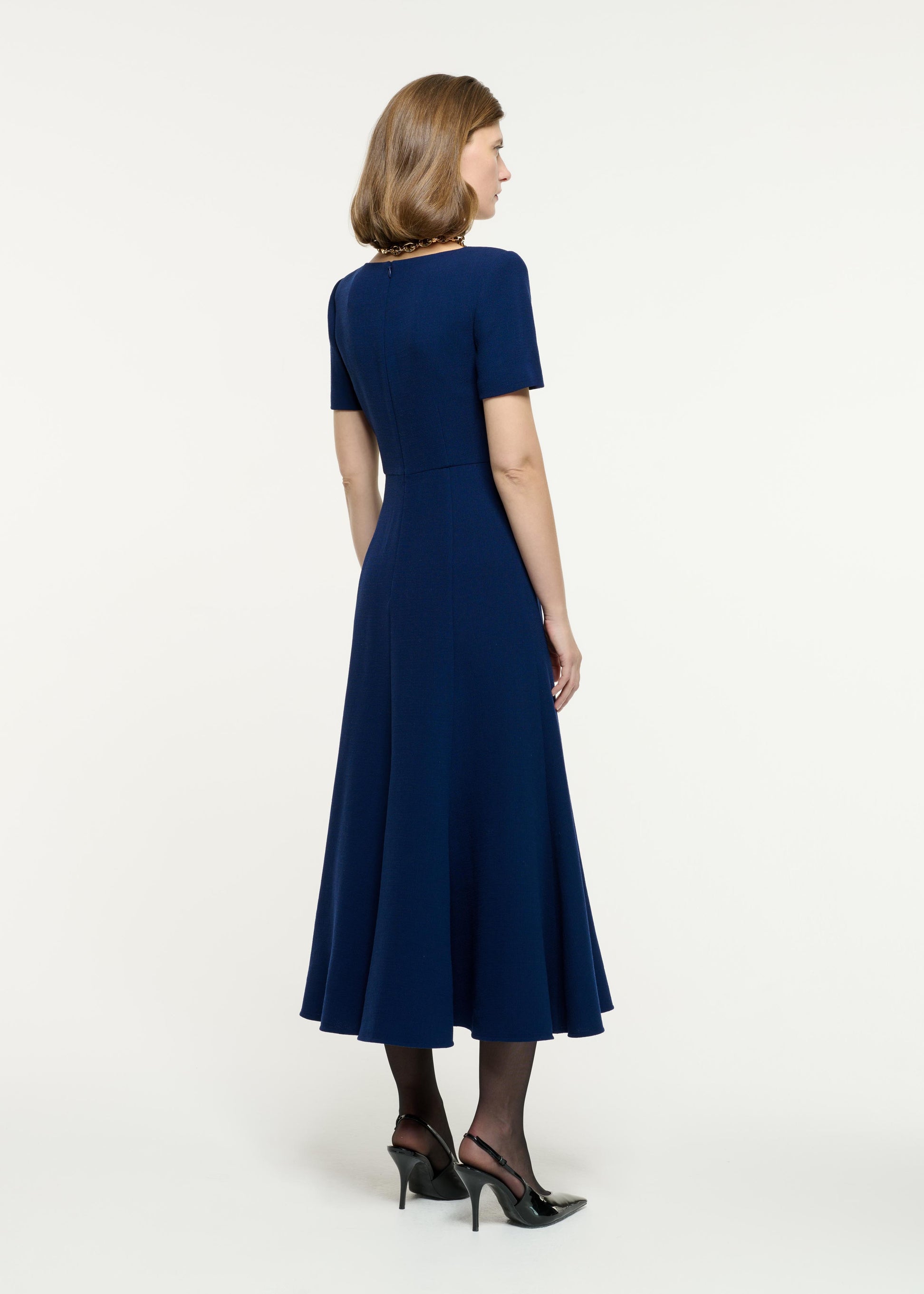 Back view of a model wearing the Short Sleeve Wool Crepe Midi Dress in Blue