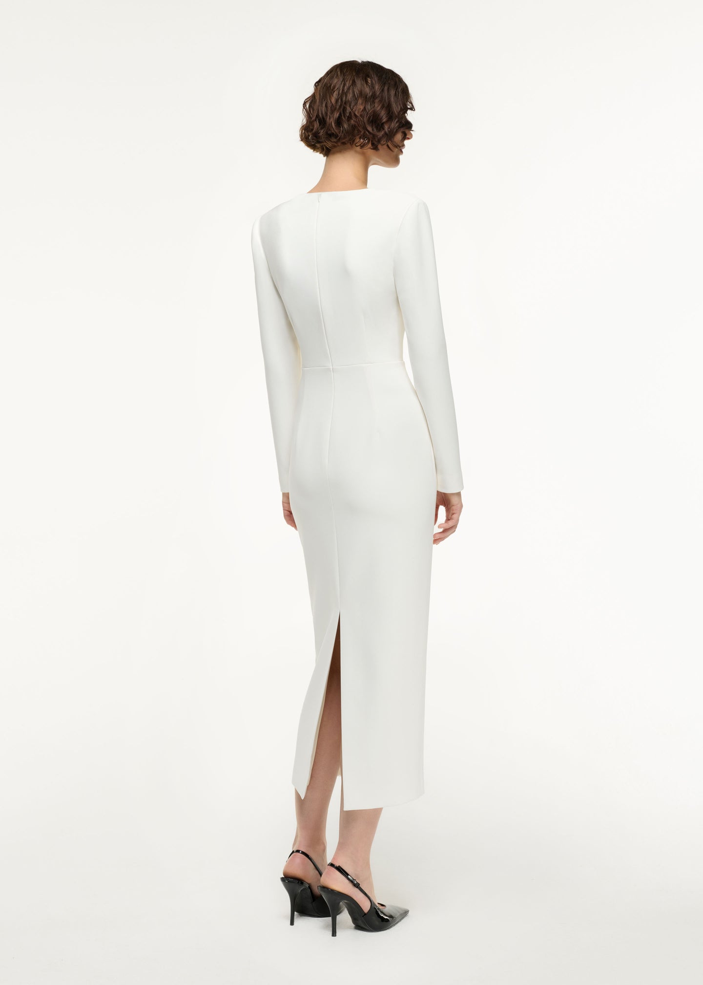 Back view of a model wearing the Long Sleeve Buckle Crepe Midi Dress in Cream