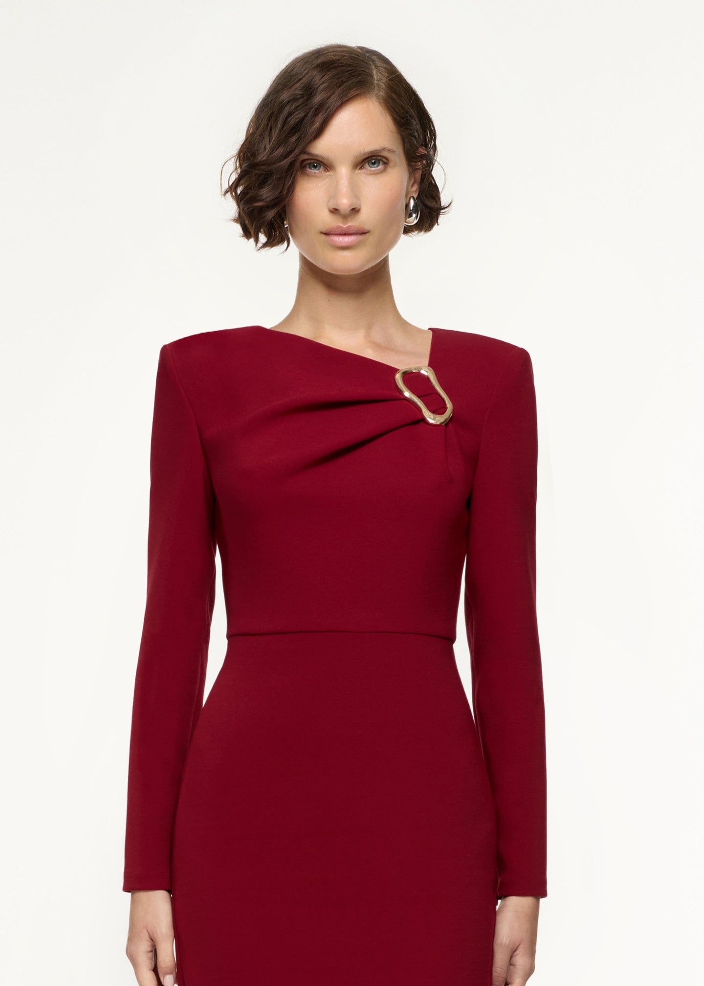 Close up of a model wearing the Long Sleeve Buckle Crepe Midi Dress in Red
