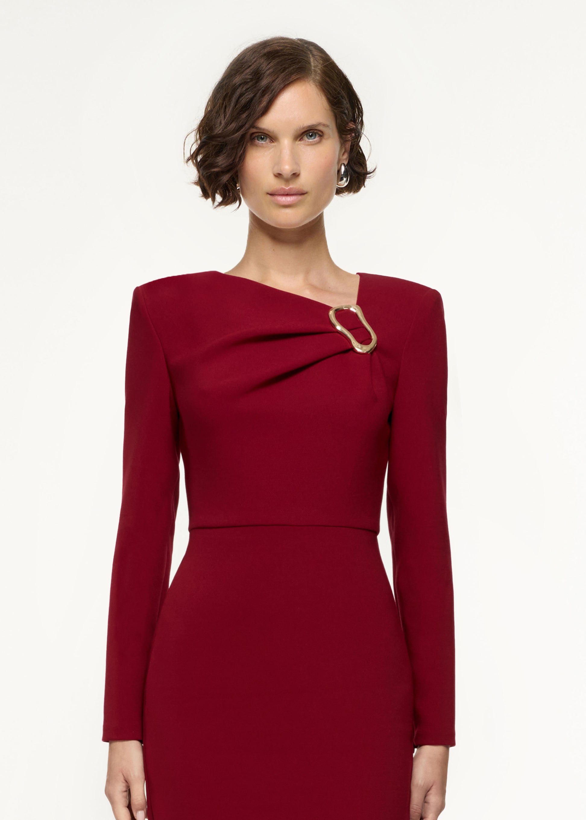 Close up of a model wearing the Long Sleeve Buckle Crepe Midi Dress in Red