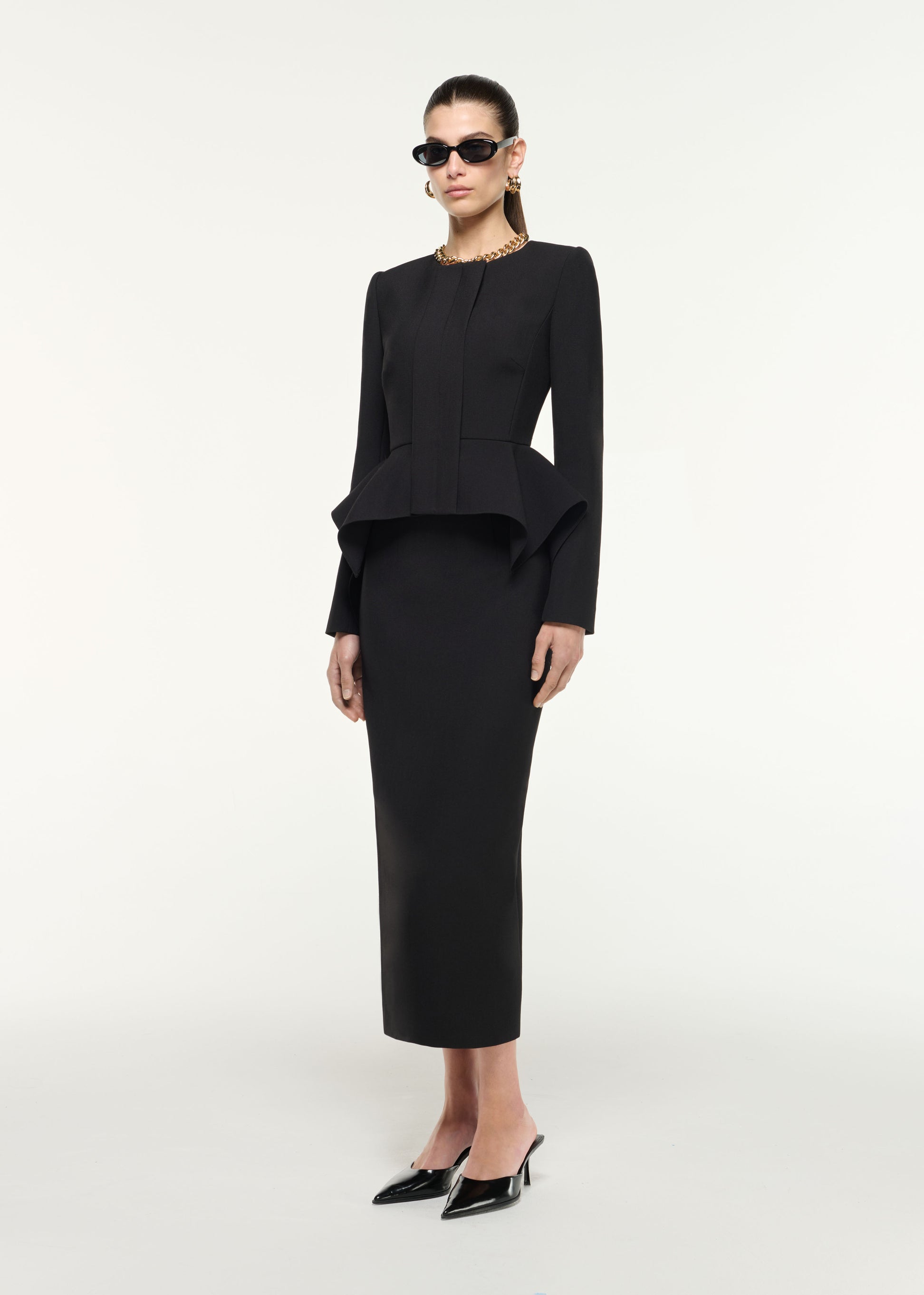 Side view of a model wearing the Crepe Midi Skirt in Black