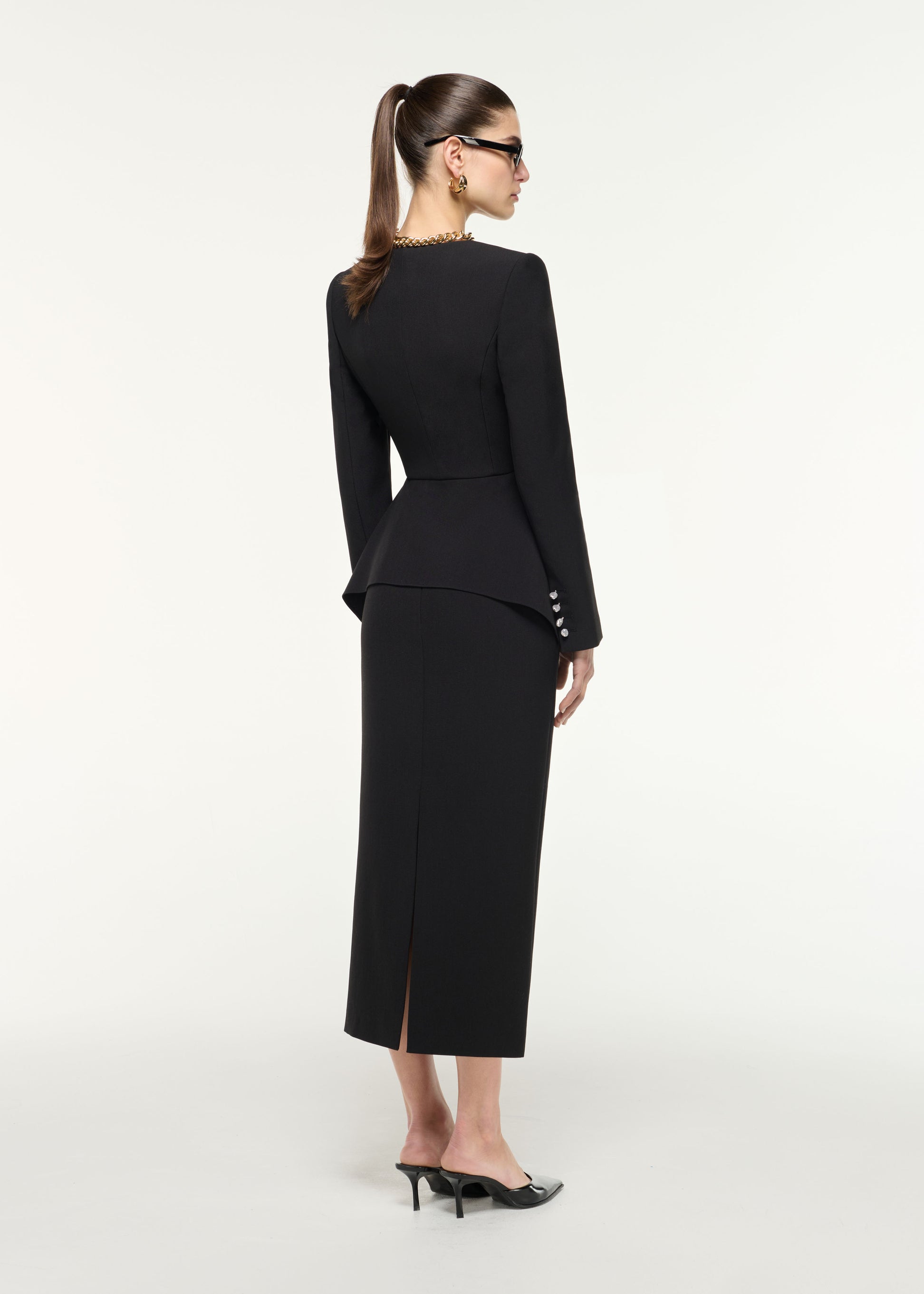 Back view of a model wearing the FOLDED COLLAR BELTED BOUCLE DRESS (test) in Black