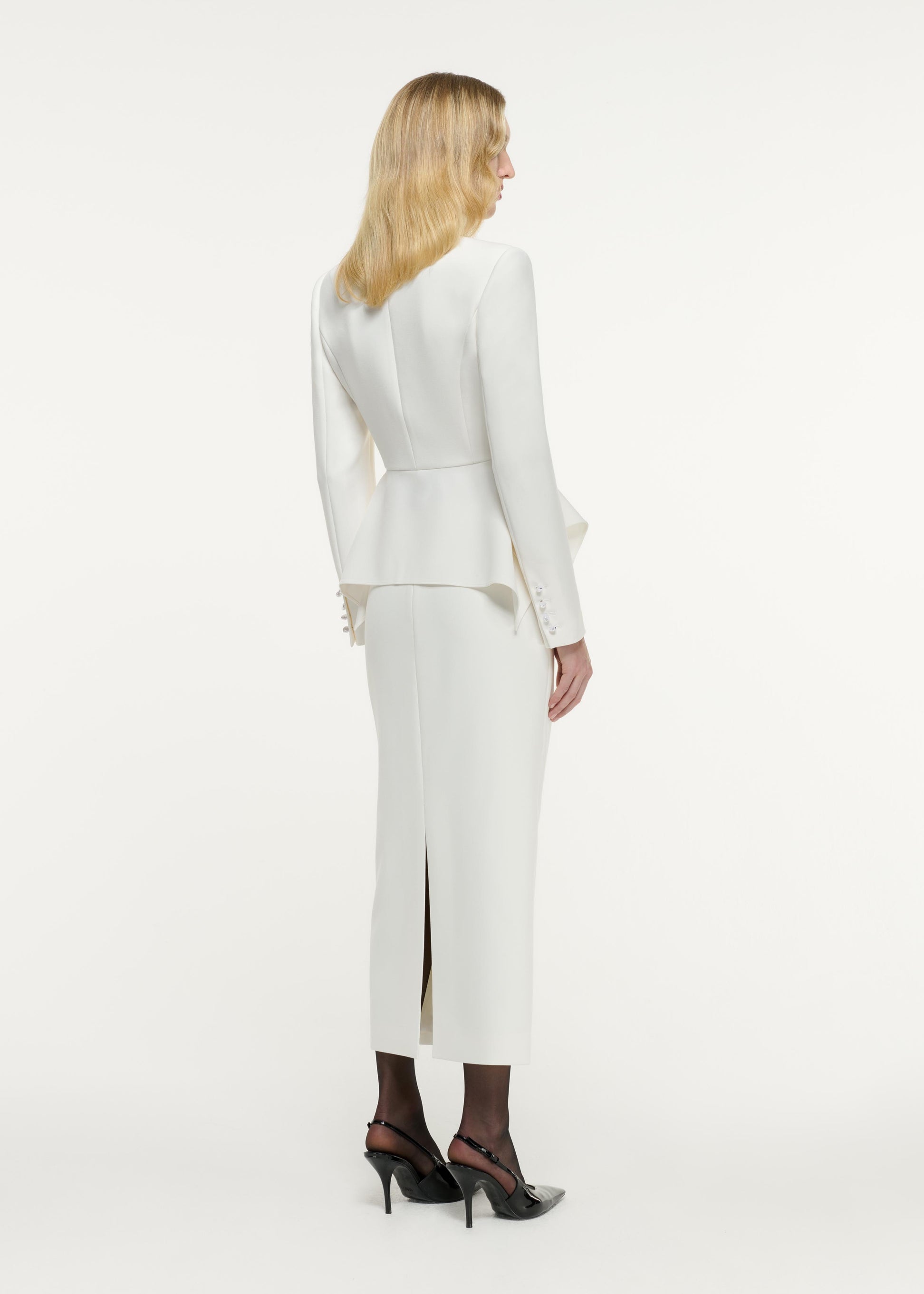 Back view of a model wearing the Peplum Crepe Jacket in Cream