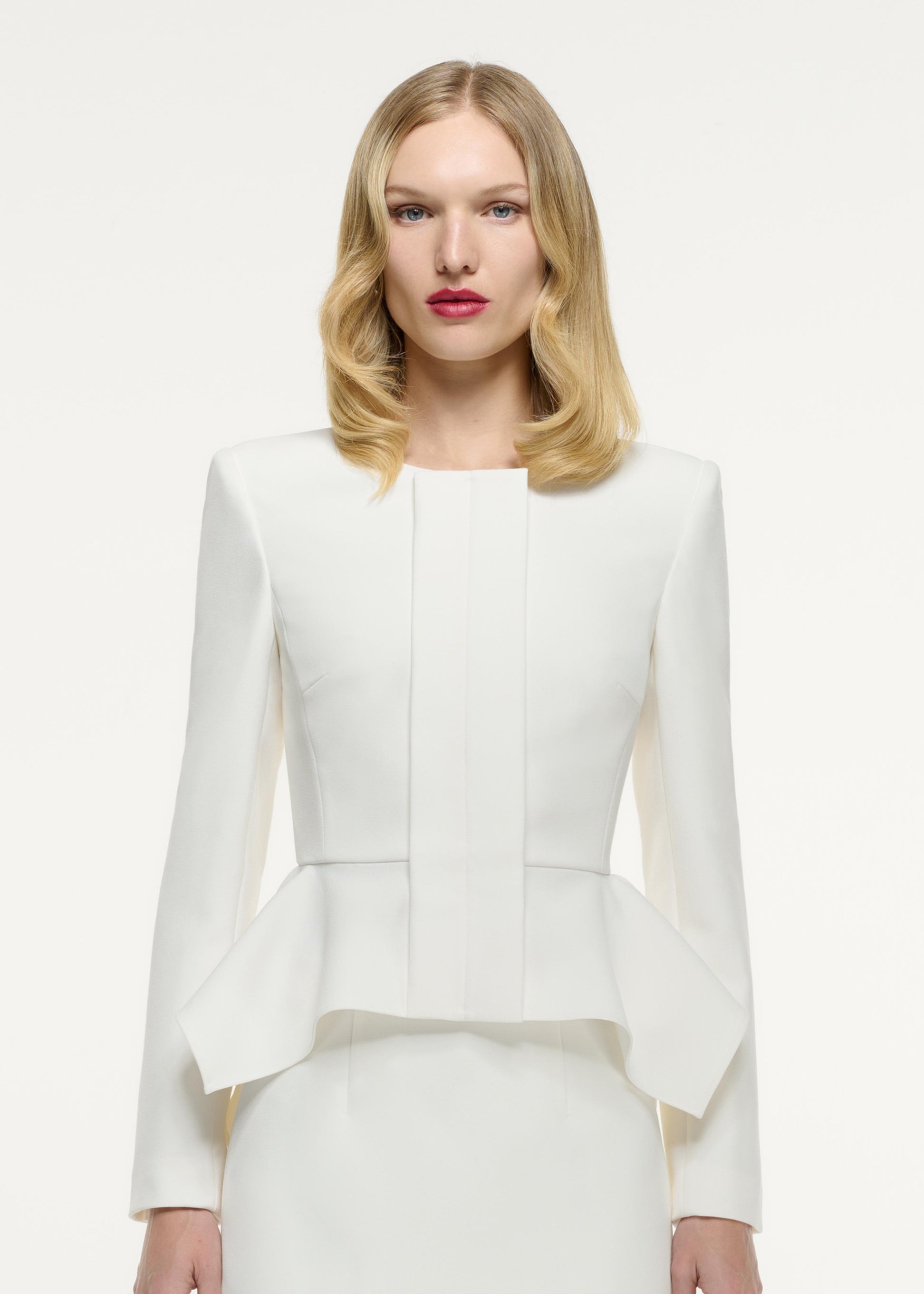 Close up of a model wearing the Peplum Crepe Jacket in Cream
