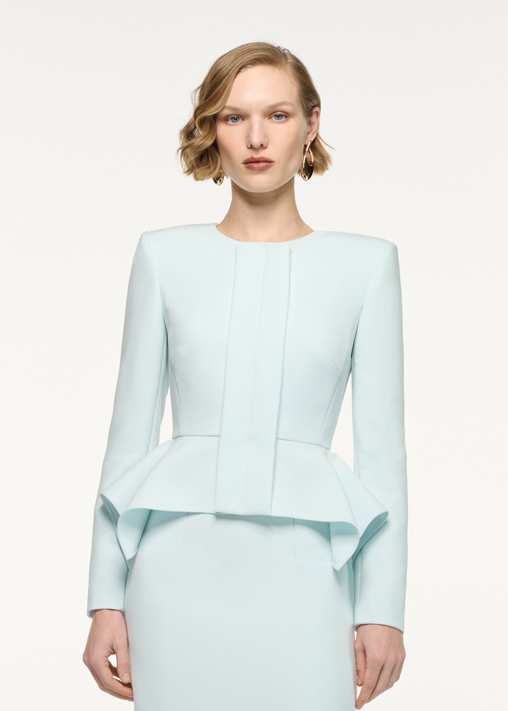 Close up of a model wearing the Peplum Crepe Jacket in Aqua