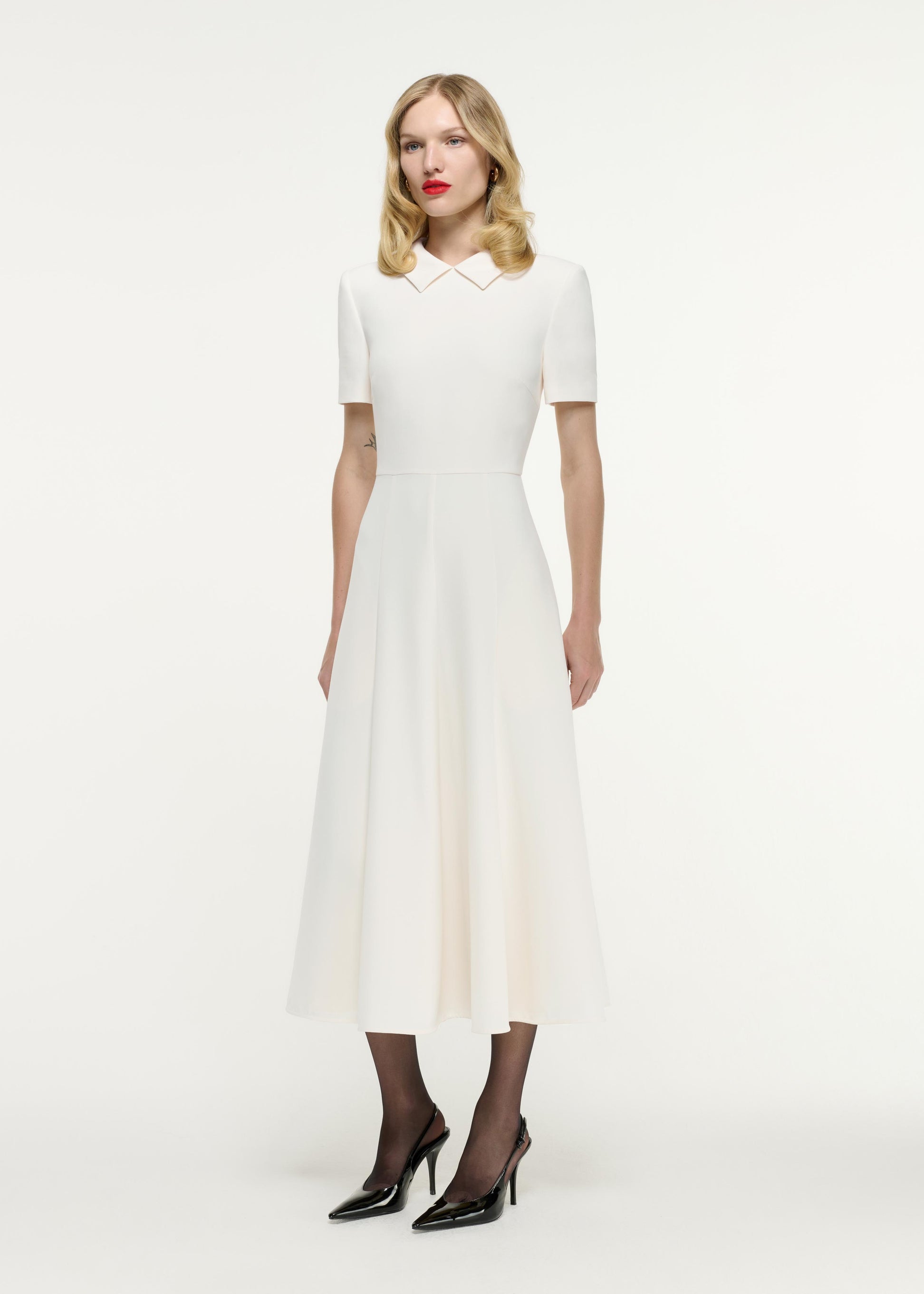 Side view of a model wearing the Short Sleeve Collar Heavy Cady Midi Dress in White
