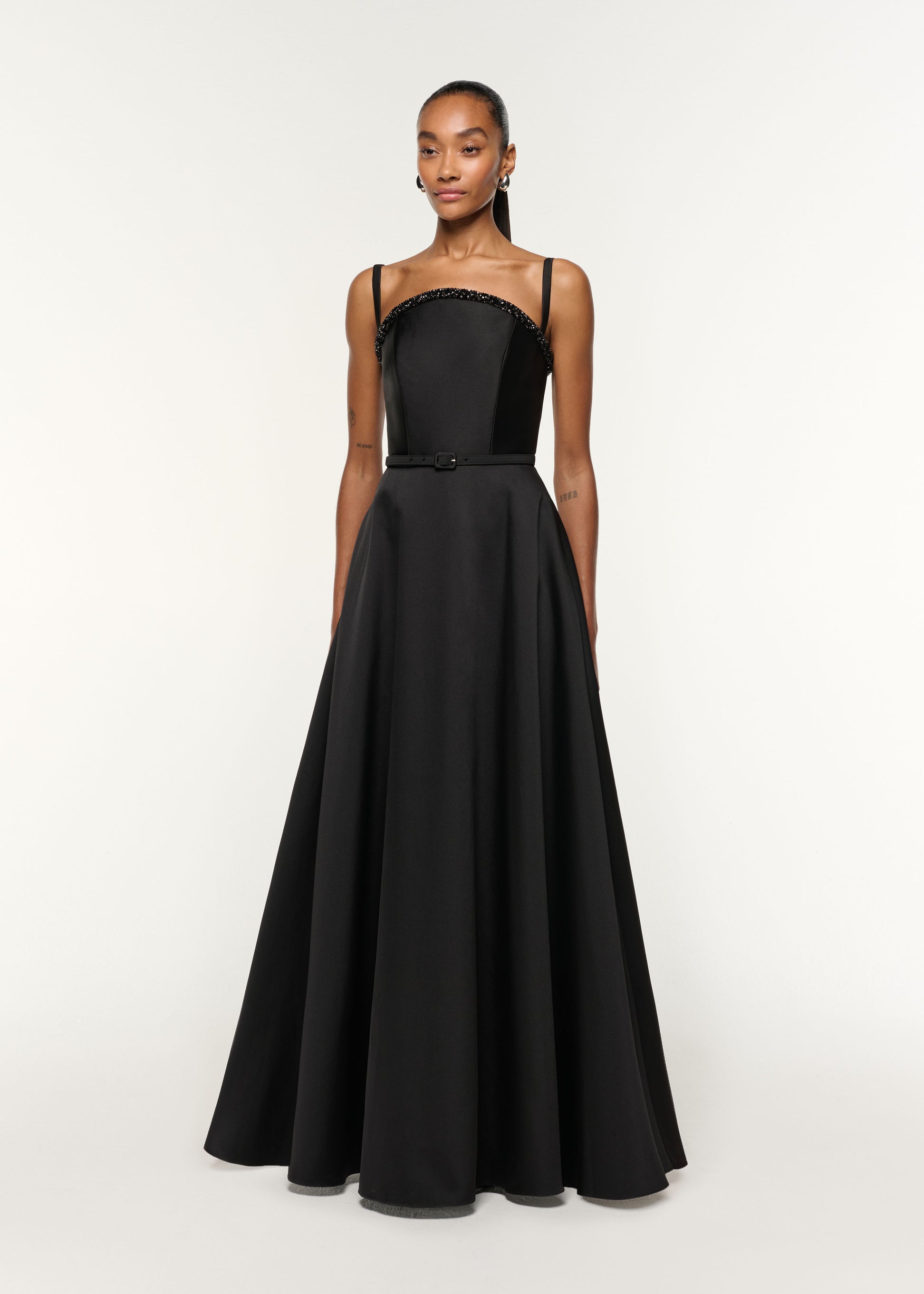 Side view of a model wearing the Curved Crystal Neckline Taffeta Gown in Black