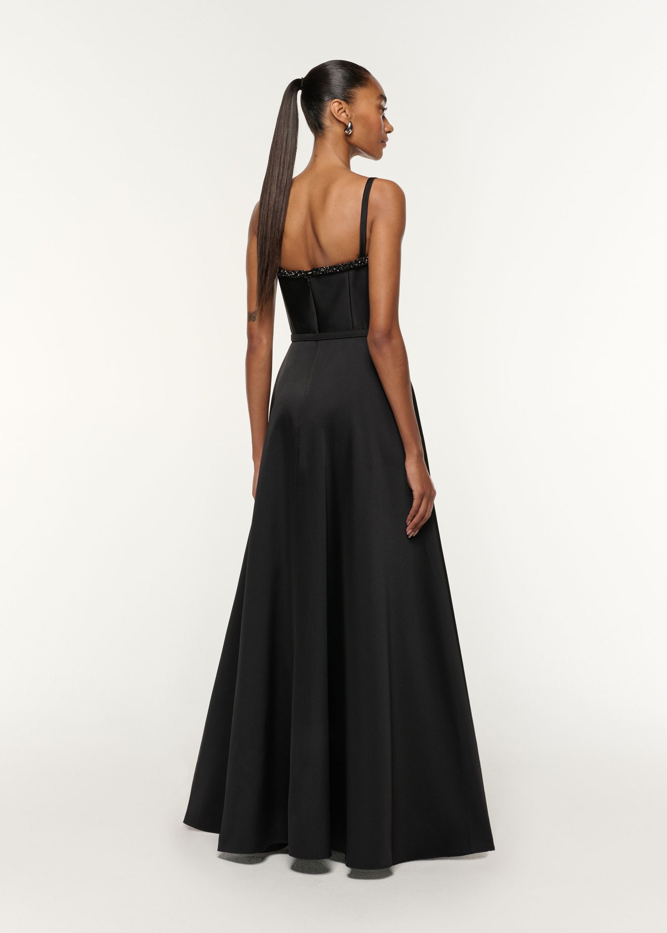 Back view of a model wearing the Curved Crystal Neckline Taffeta Gown in Black