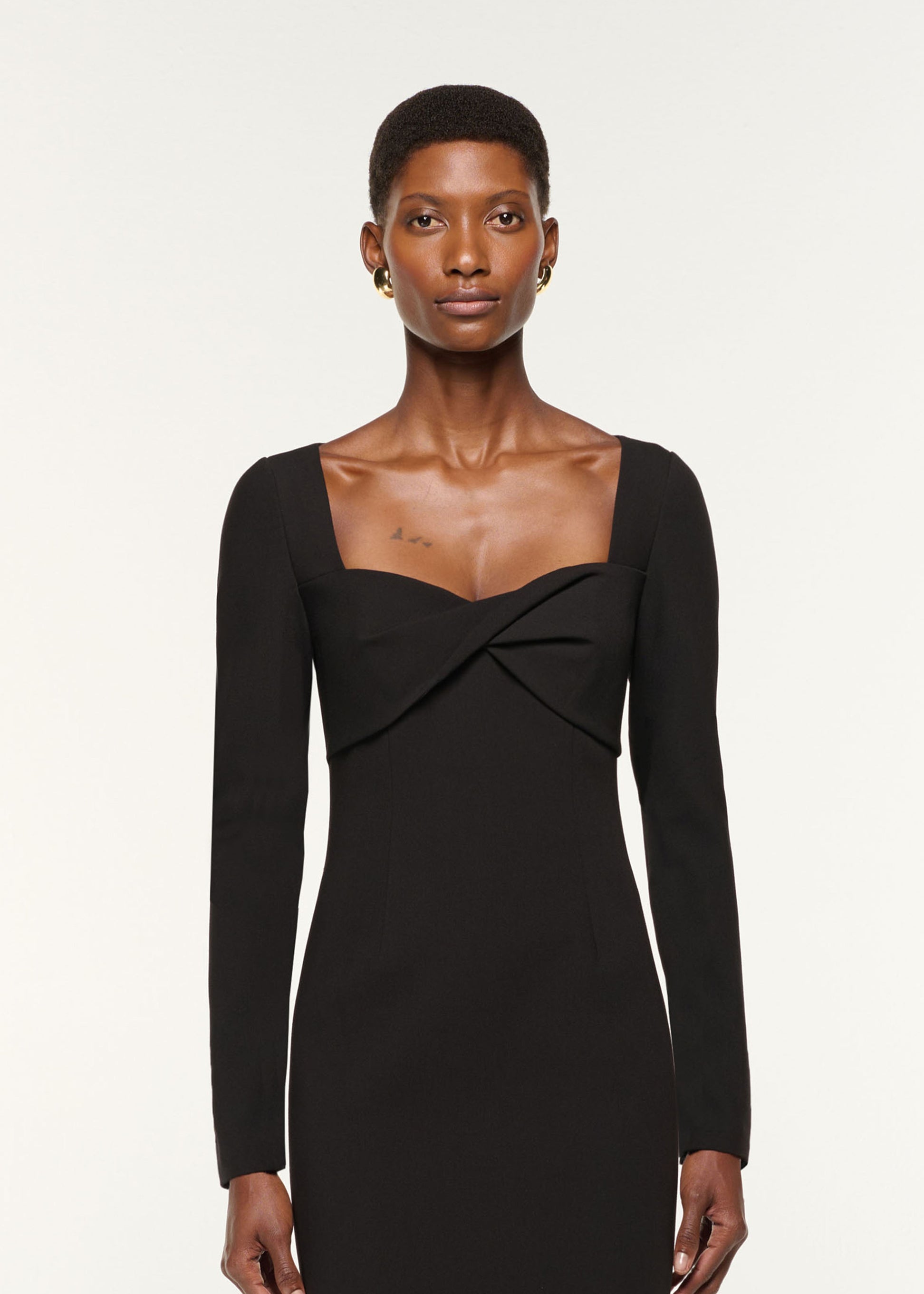 Close up of a model wearing the Twist Drape Stretch Crepe Dress in Black