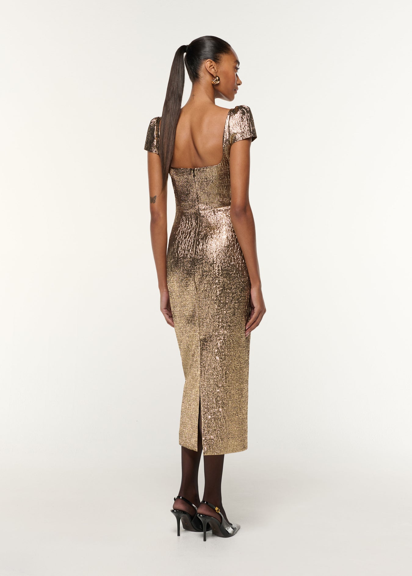 Back view of a model wearing the Pleated Drape Metallic Jacquard Dress in Gold