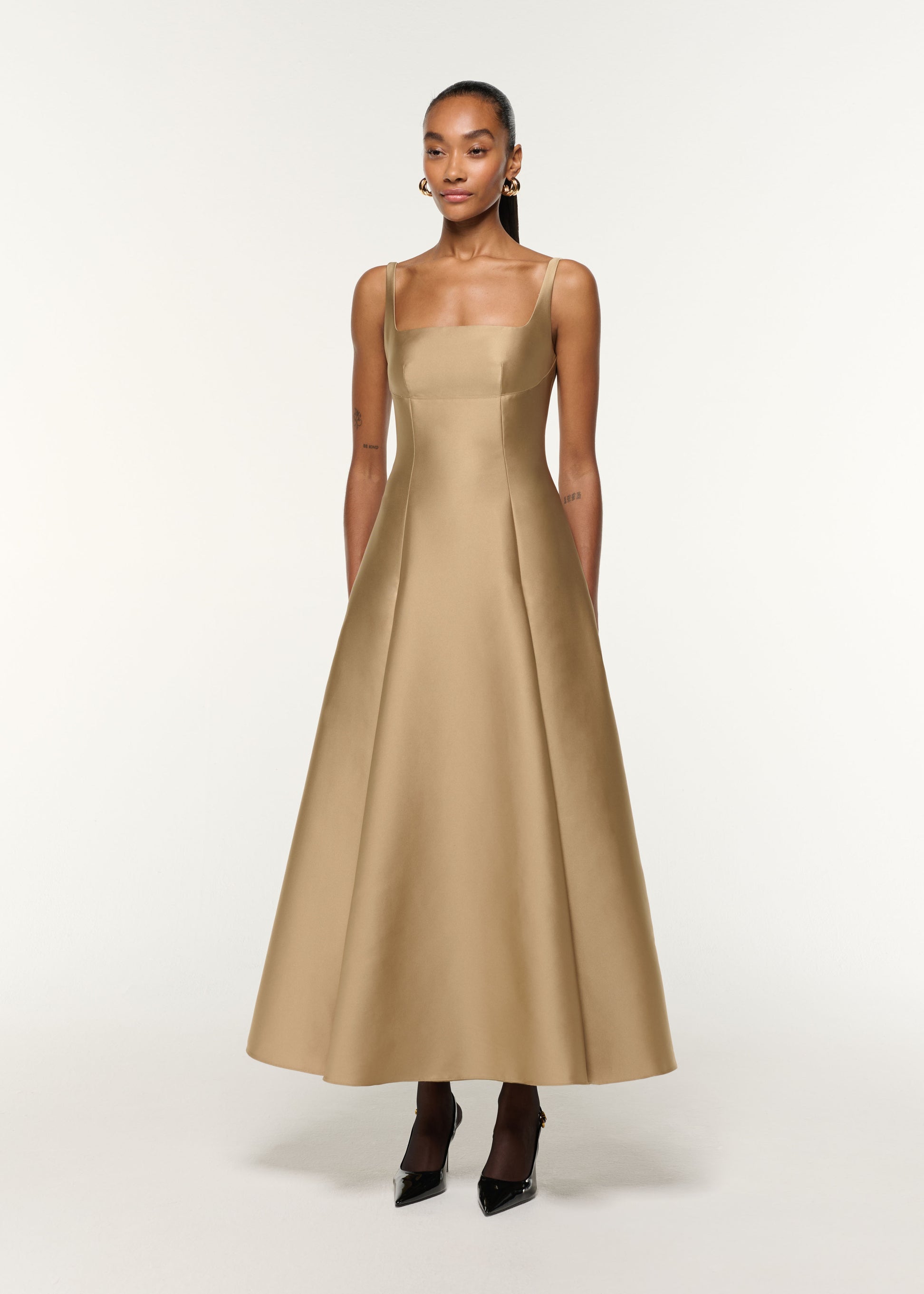 Side view of a model wearing the Square Neckline Taffeta Dress in Gold
