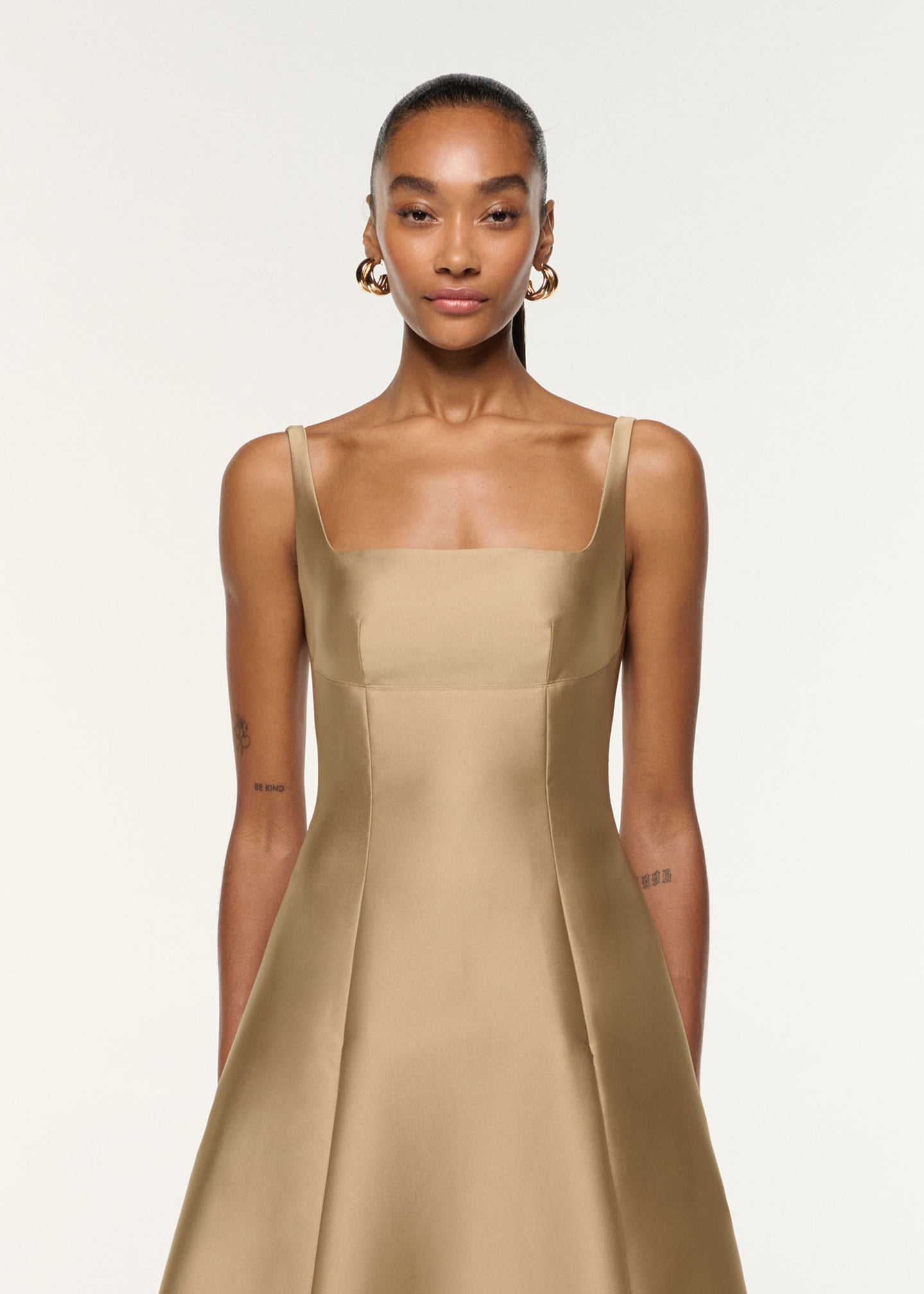 Close up of a model wearing the Square Neckline Taffeta Dress in Gold