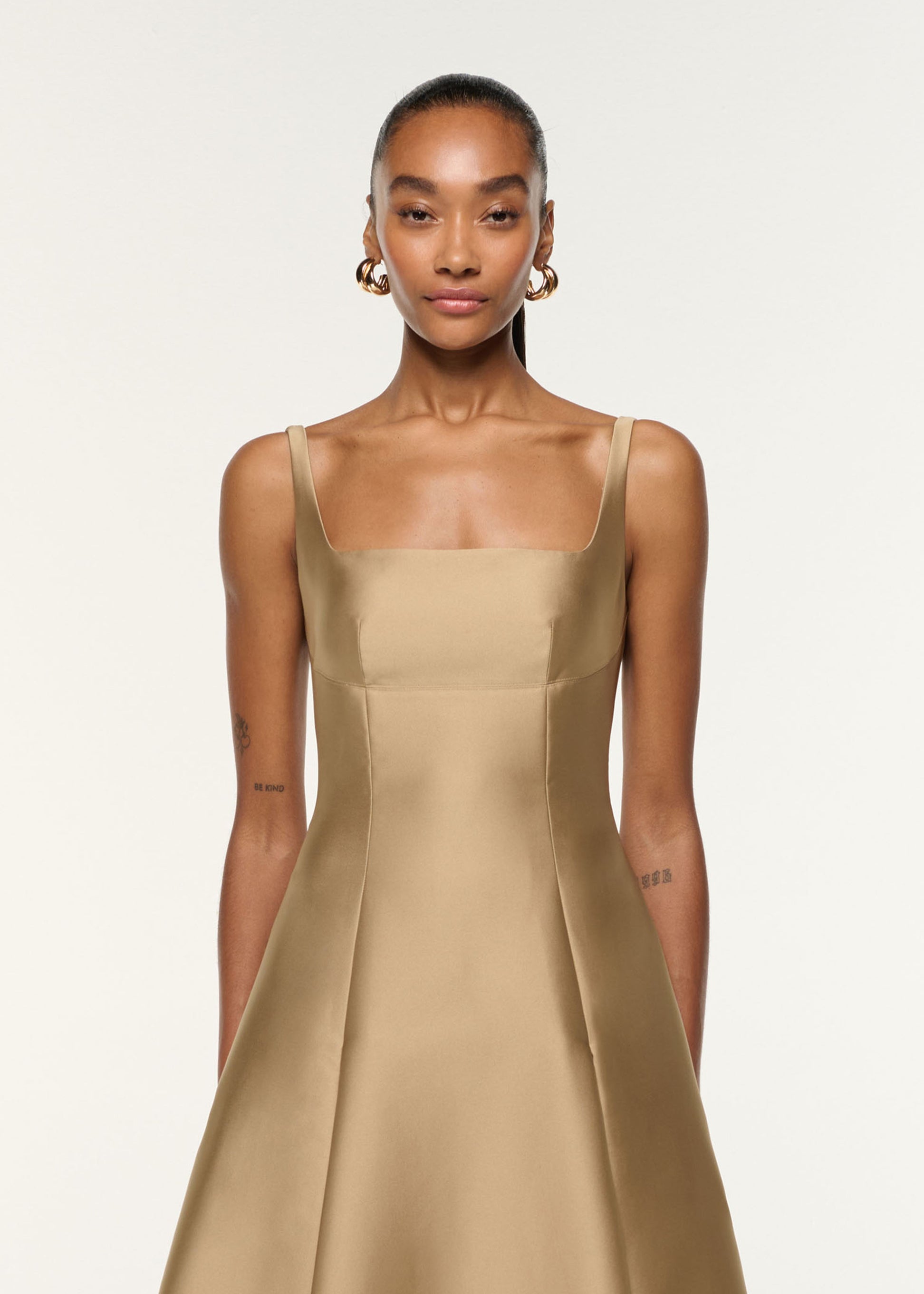 Close up of a model wearing the Square Neckline Taffeta Dress in Gold