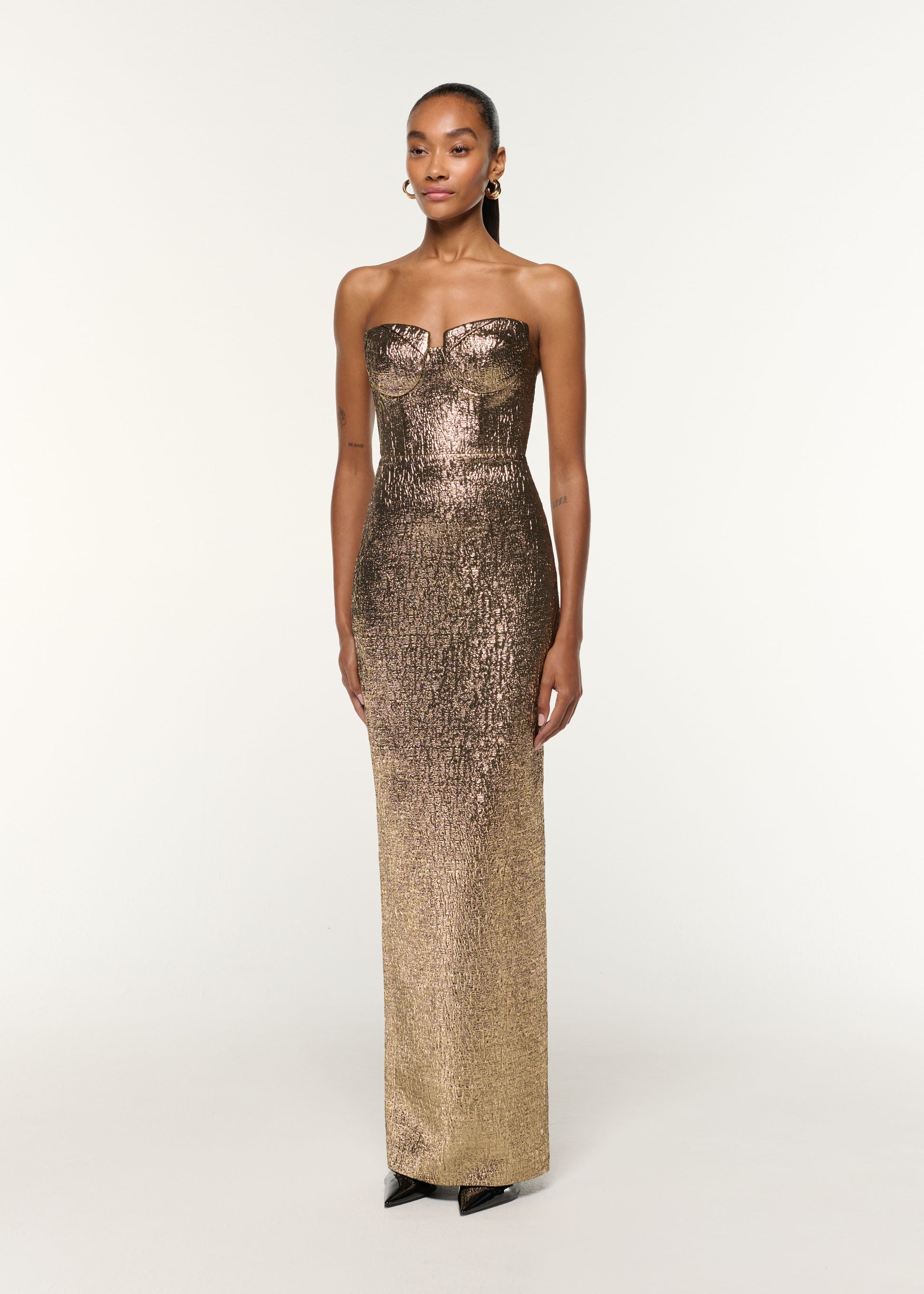 Side view of a model wearing the Pleated Bust Metallic Jacquard Gown in Gold