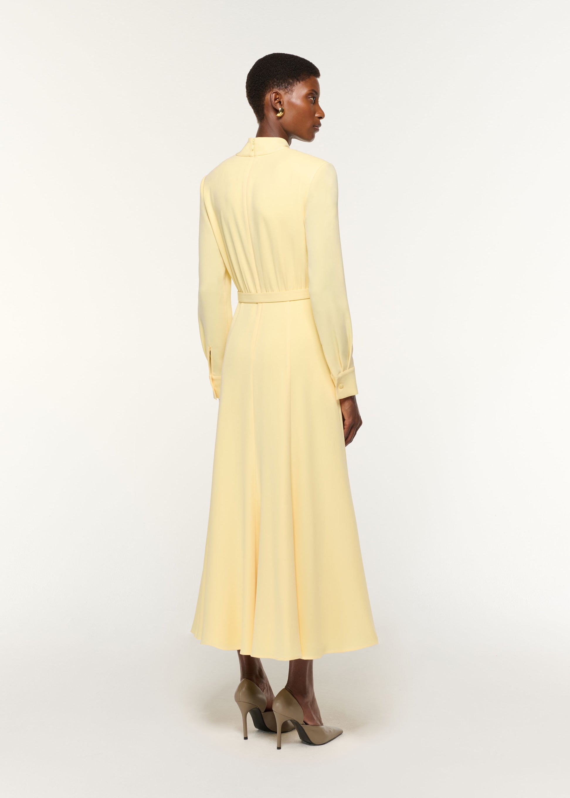 Back view of a model wearing the Light Cady Cut Out Dress in Yellow