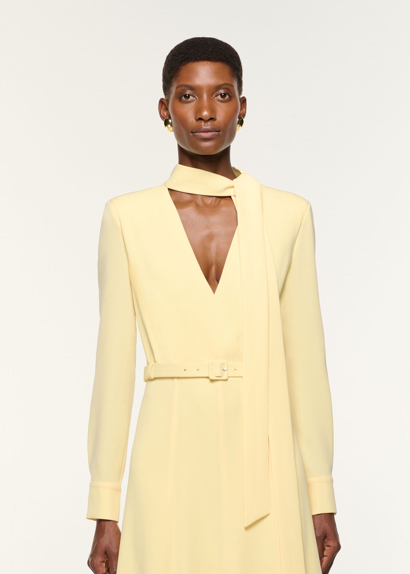 Close up of a model wearing the Light Cady Cut Out Dress in Yellow