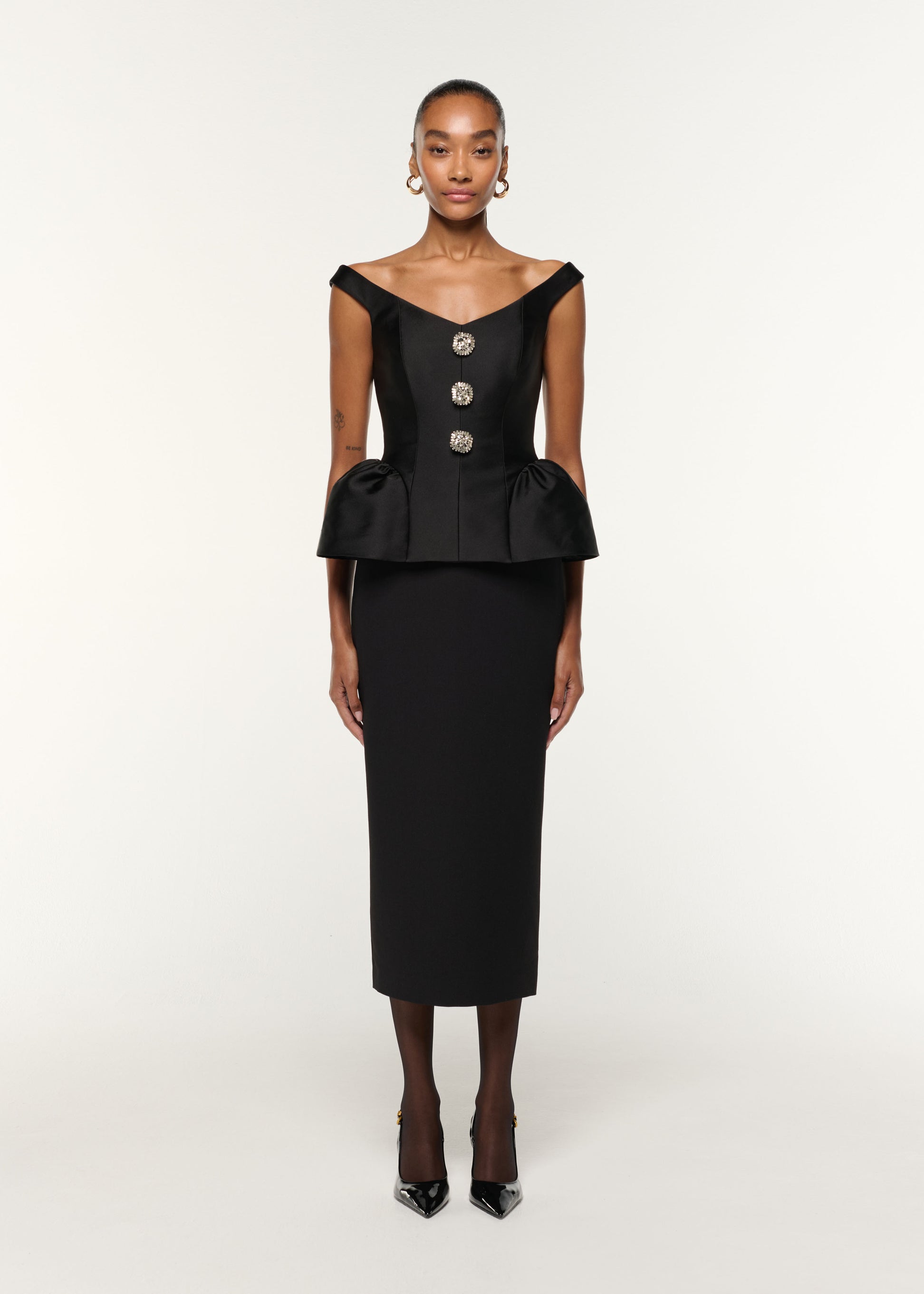 Front view of a model wearing the Crystal Button Peplum Taffeta Crepe Dress in Black