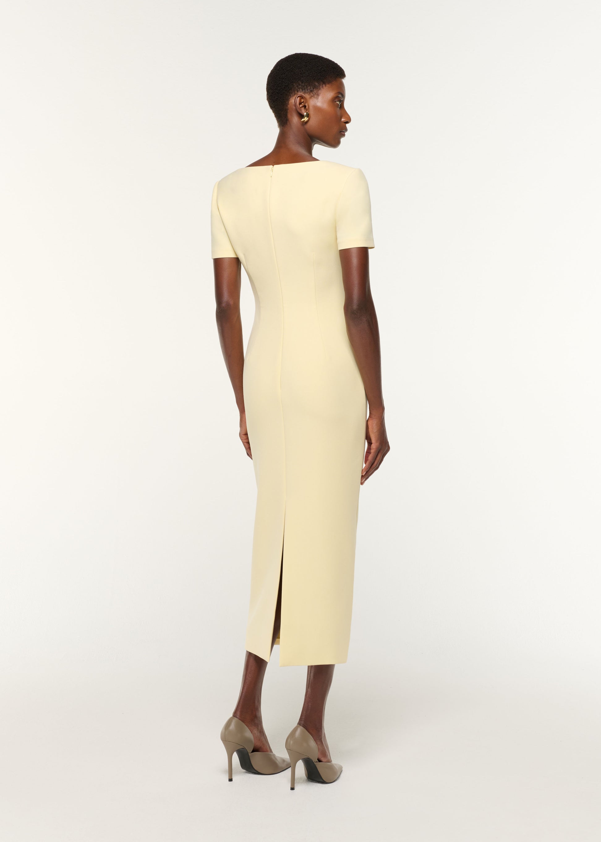 Back view of a model wearing the Asymmetric Drape Crepe Dress in Yellow